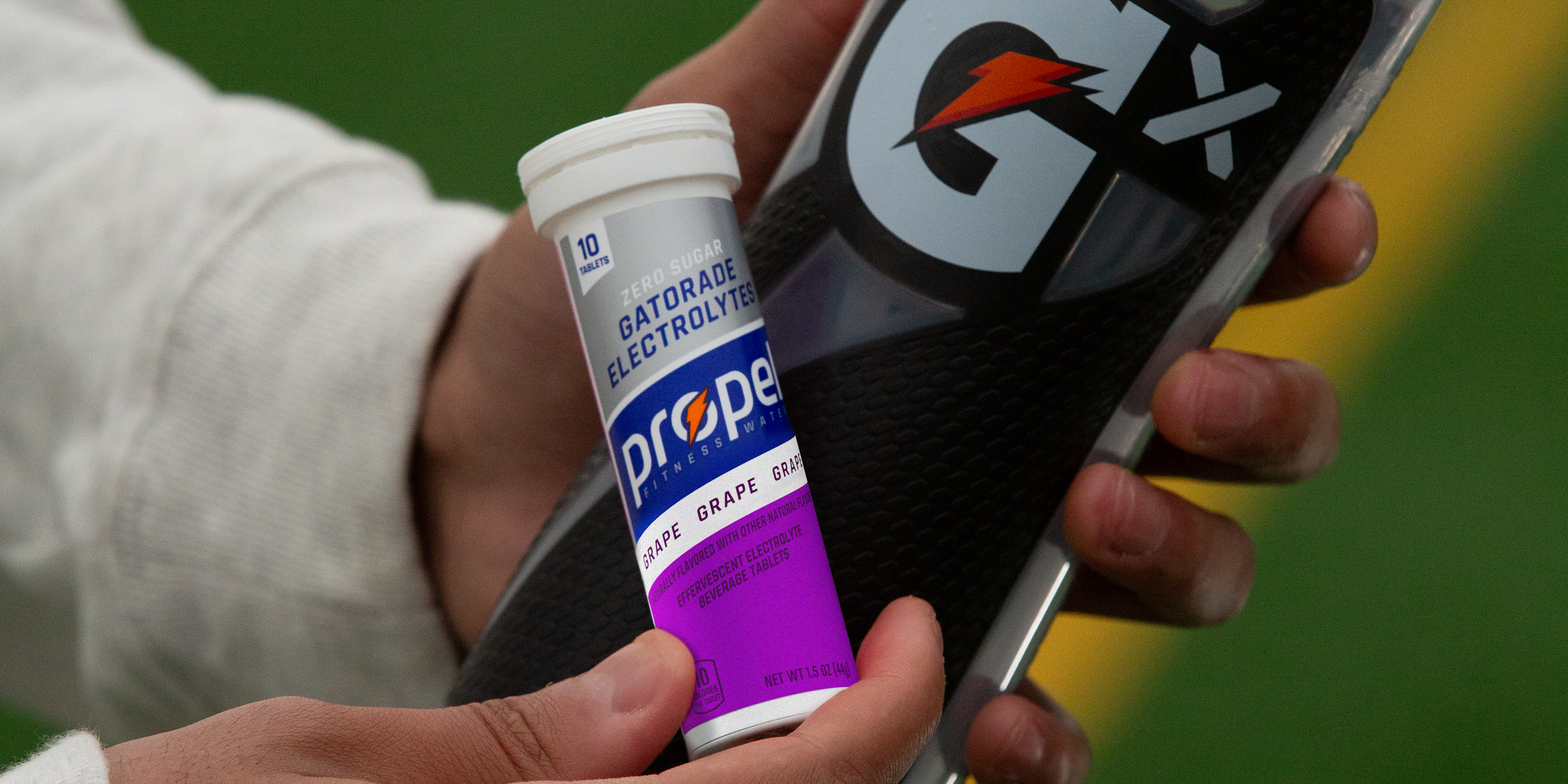 Propel Tablet Grape pack with Gx Squeeze bottle in athlete's hands.