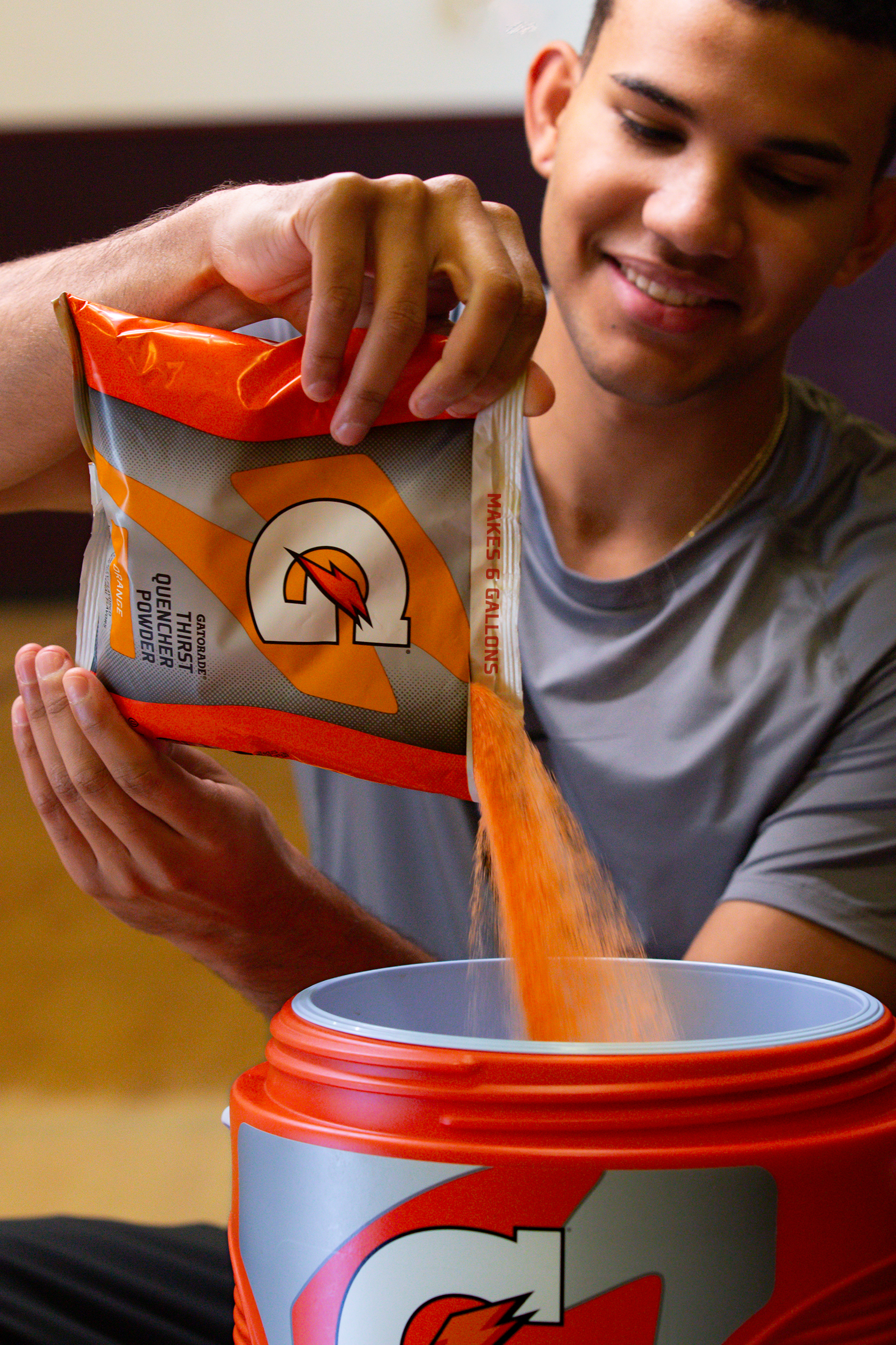 Gatorade Thirst Quencher 6 gallon bag of Orange powder being poured into cooler.