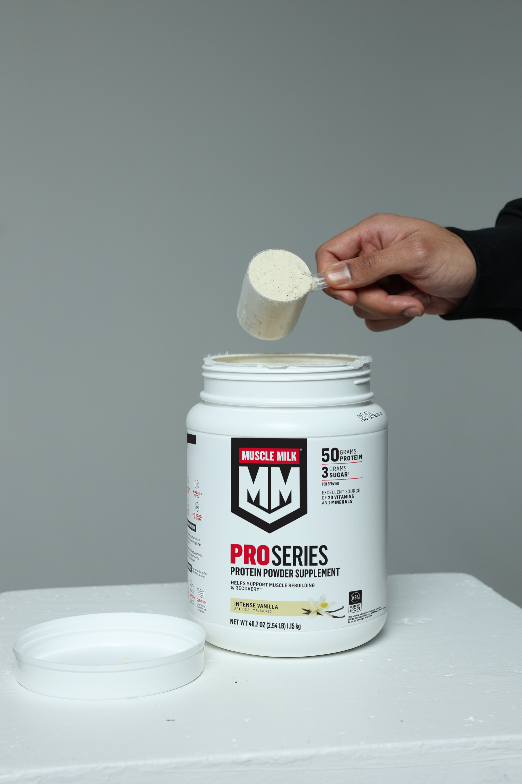 Muscle Milk Pro Series Intense Vanilla protein powder being scooped out of canister