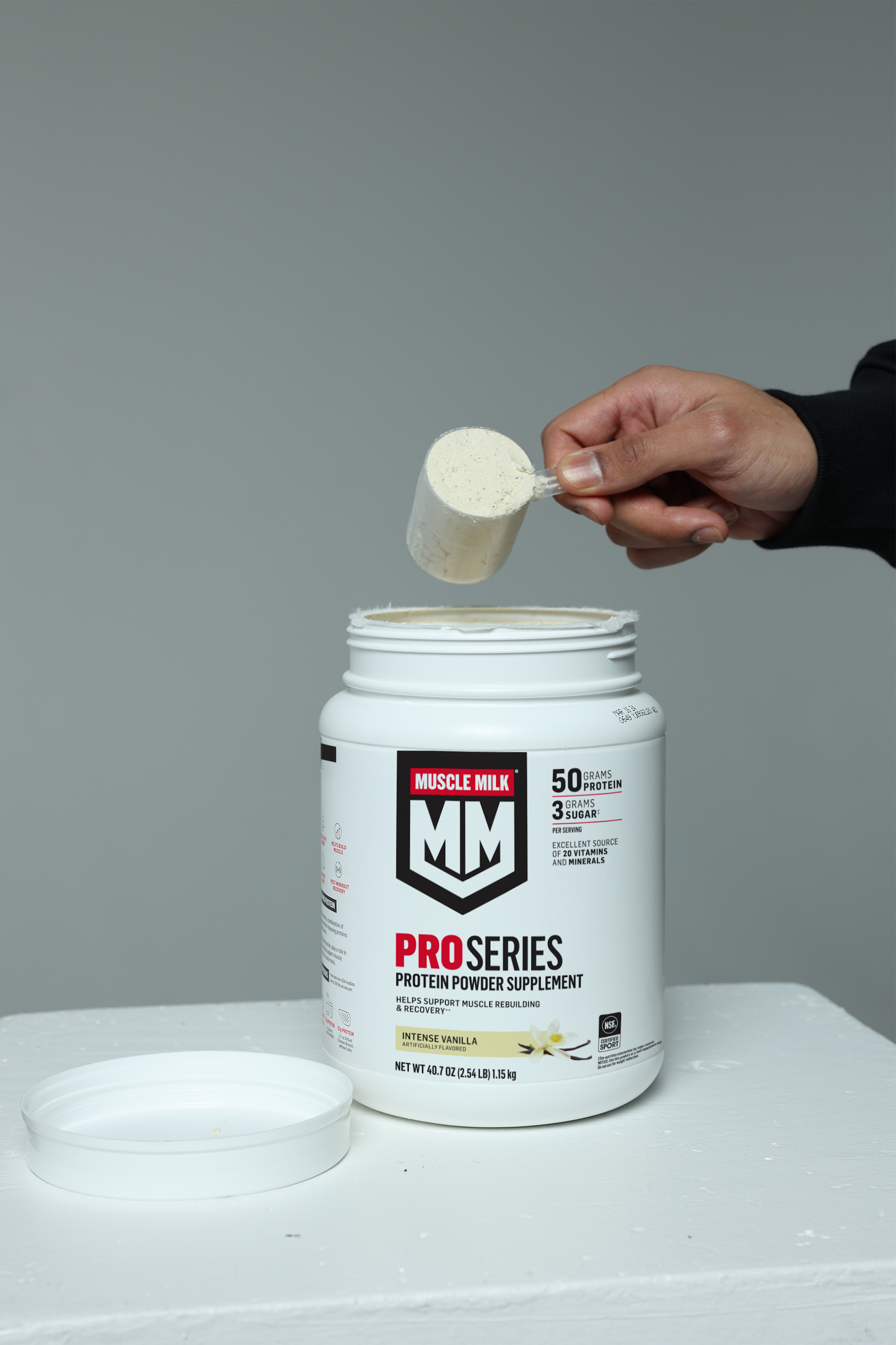 Muscle Milk Pro Series Intense Vanilla protein powder being scooped out of canister