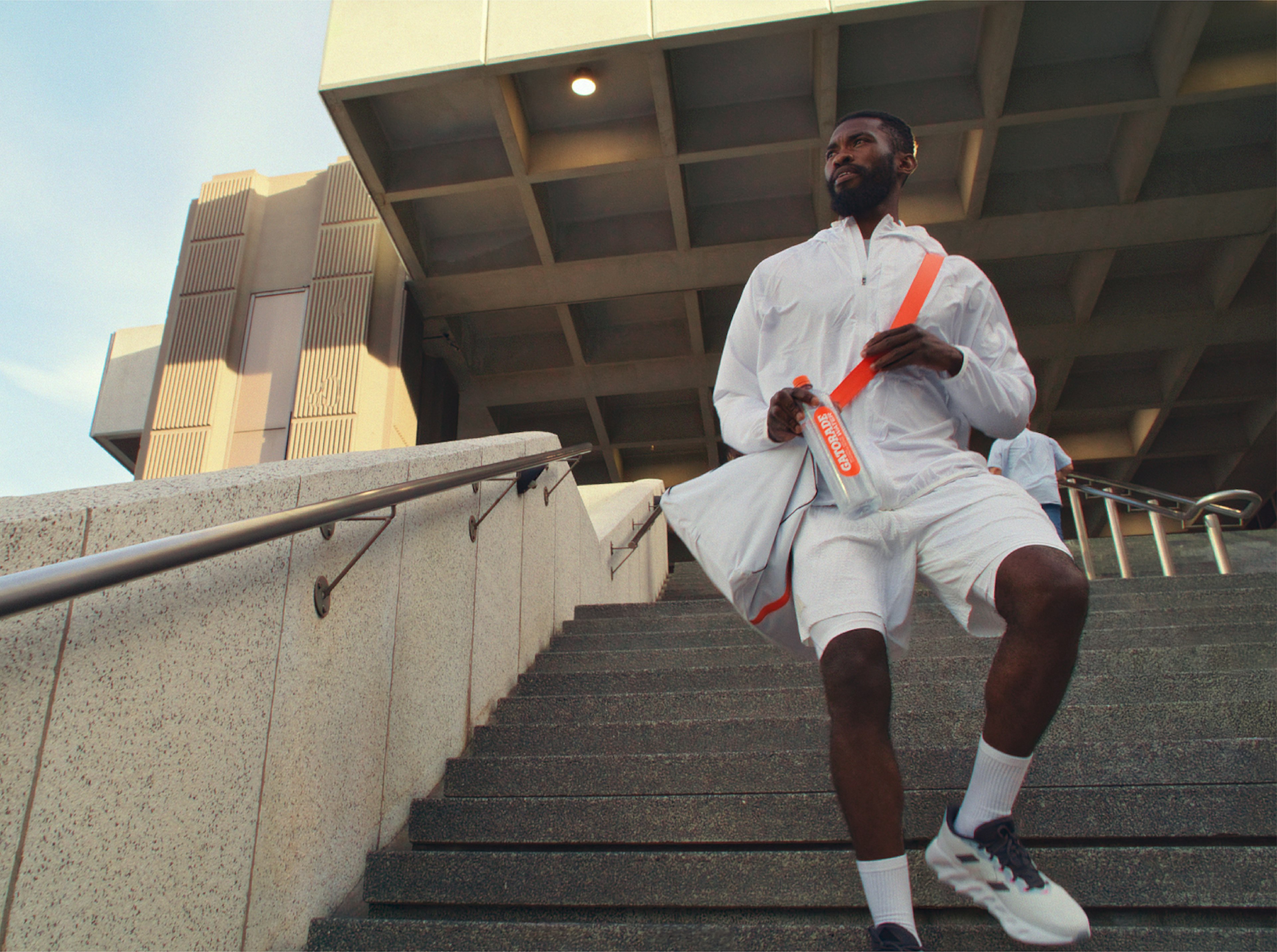 athlete walking down stairs with gatorade water bottle in hand