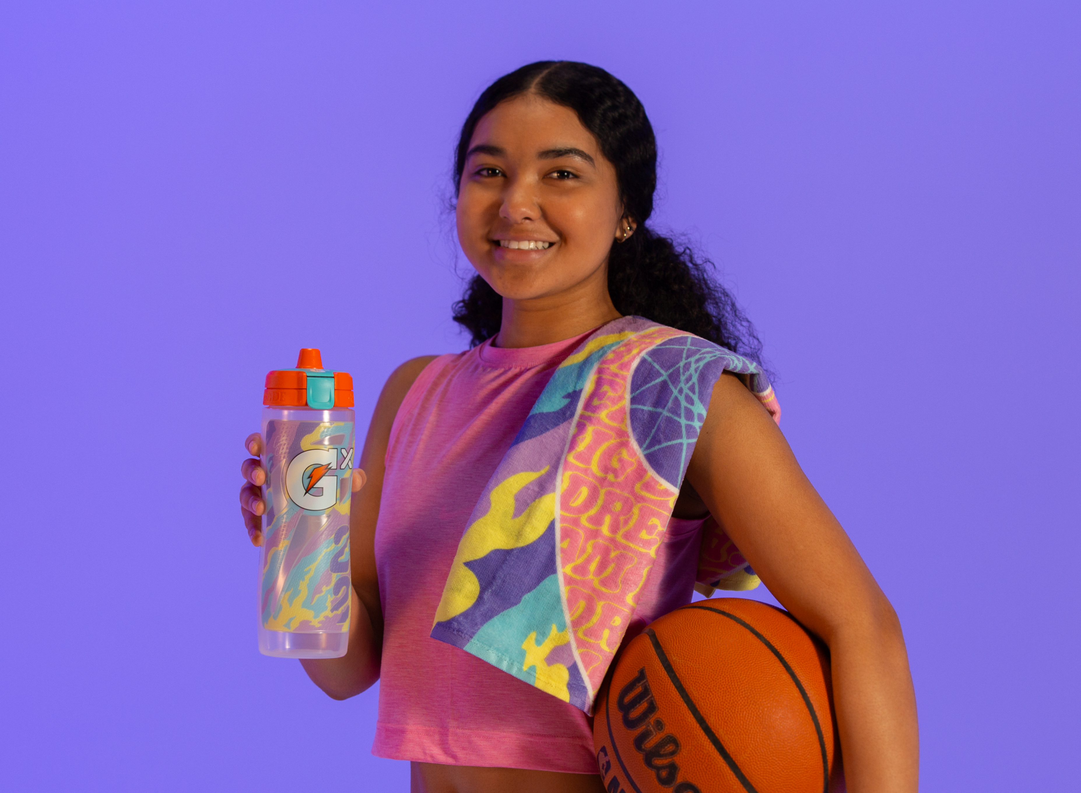 Athlete holding Caitlin Clark bottle, towel and basketball