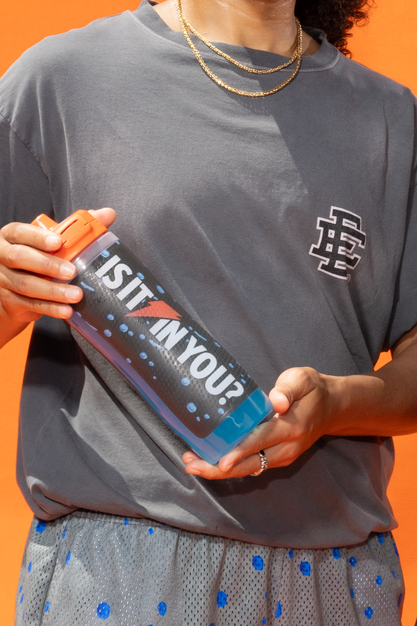 Model holding Eric Emanuel Bottle while wearing Gatorade Shirt
