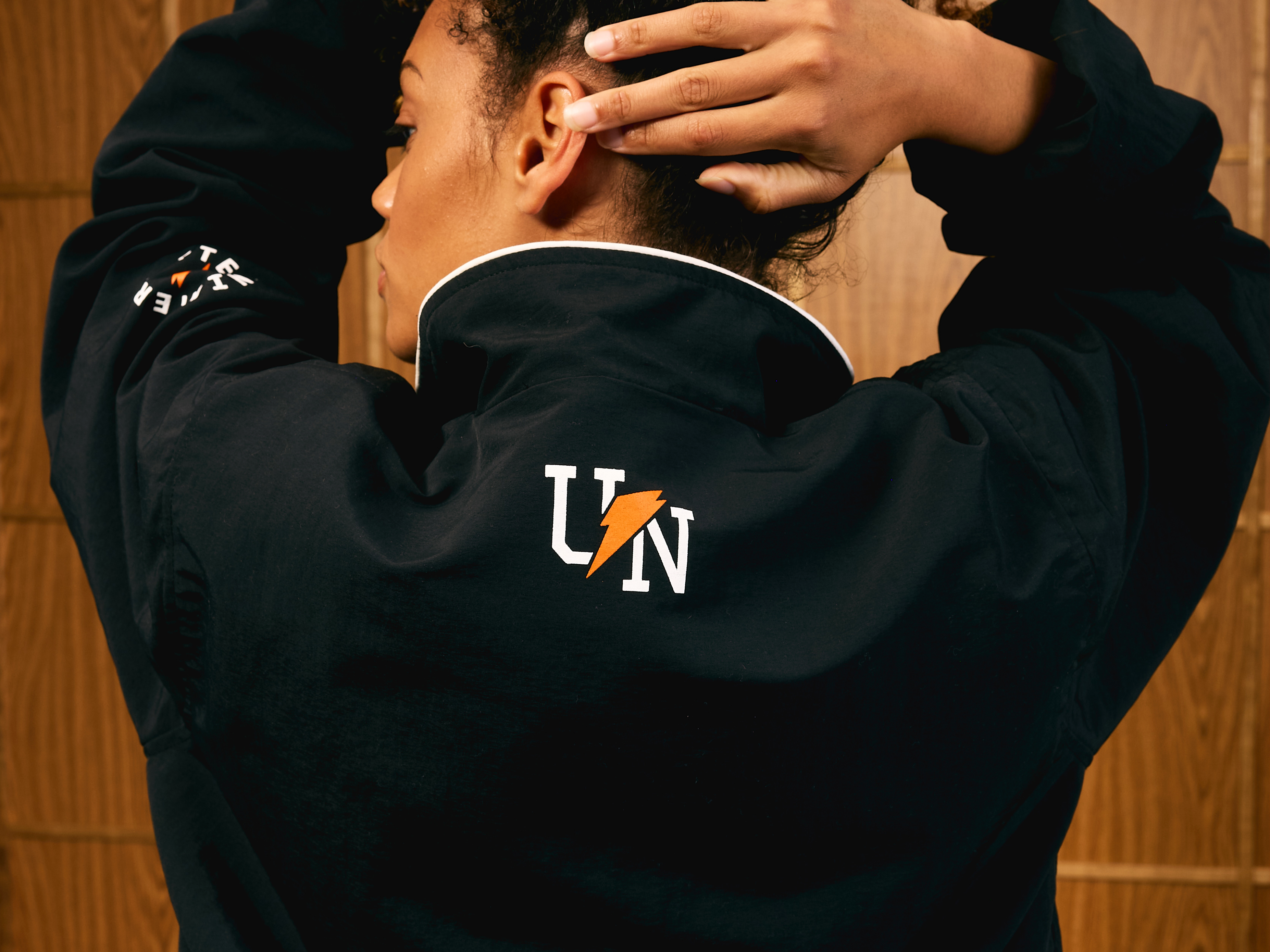 Woman showing the back of the Gatorade x UNINTERRUPTED Track Jacket.