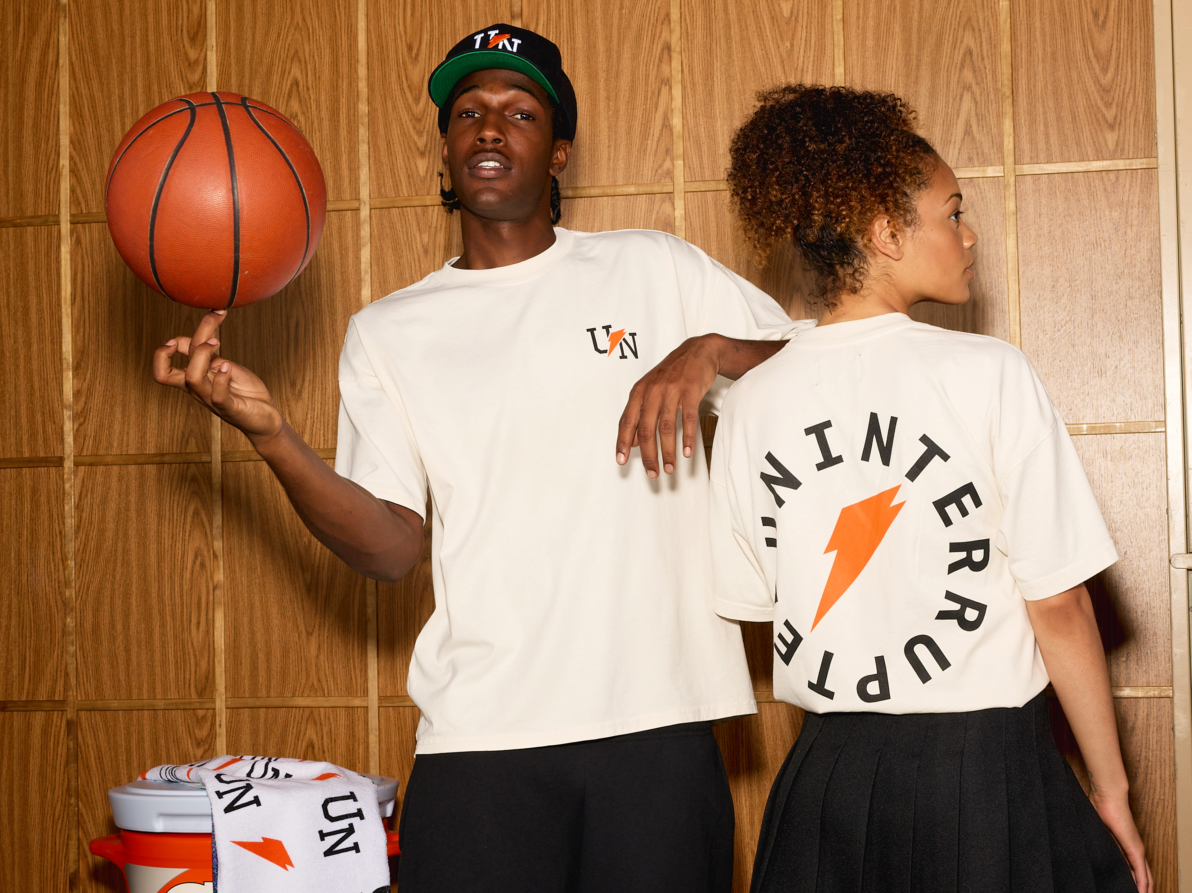 Man and woman wearing the Gatorade x UNINTERRUPTED Drop items.
