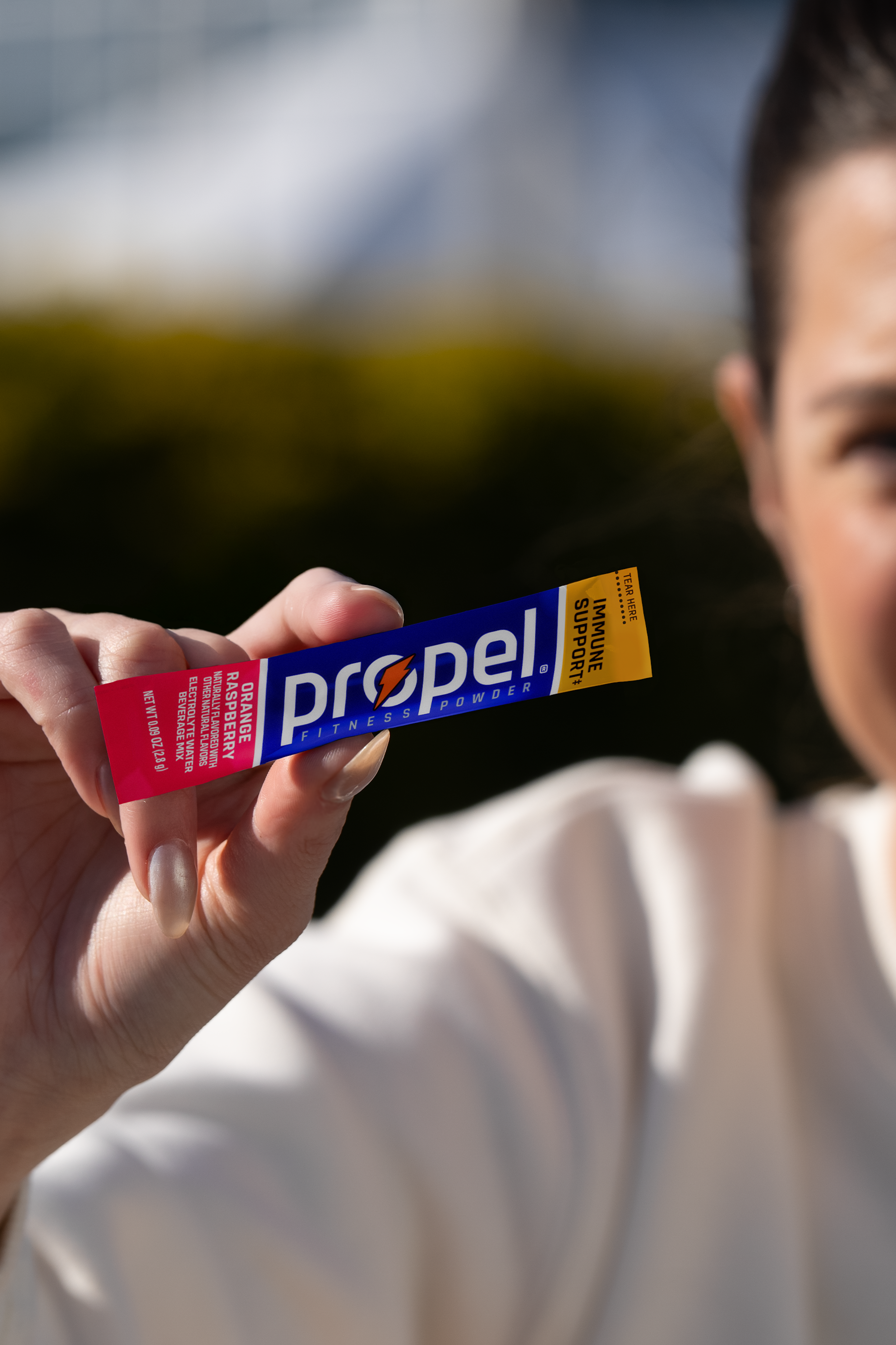 Propel powder orange raspberry in athletes hand
