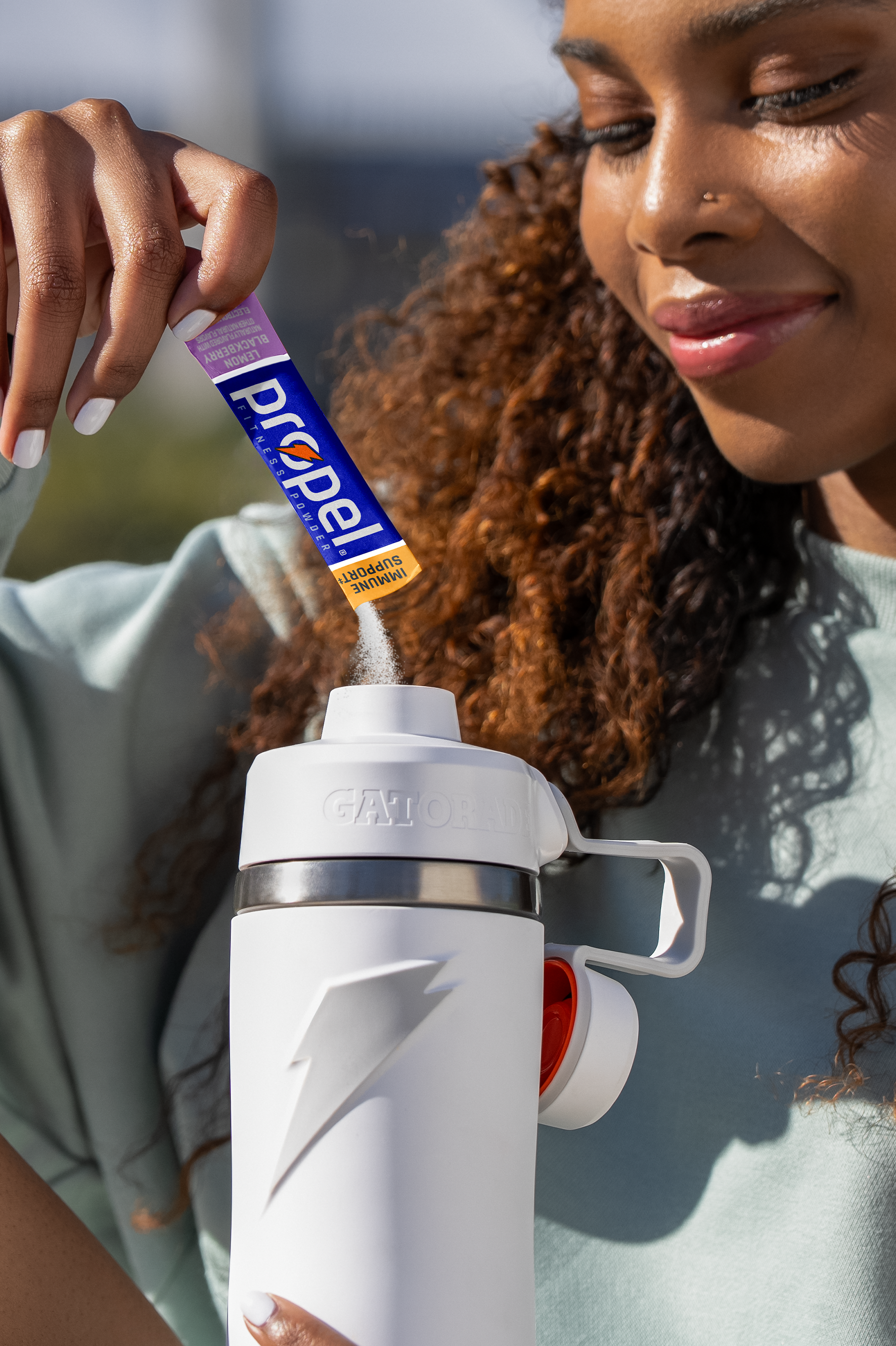 Propel powder lemon blackberry being poured into overtime bottle