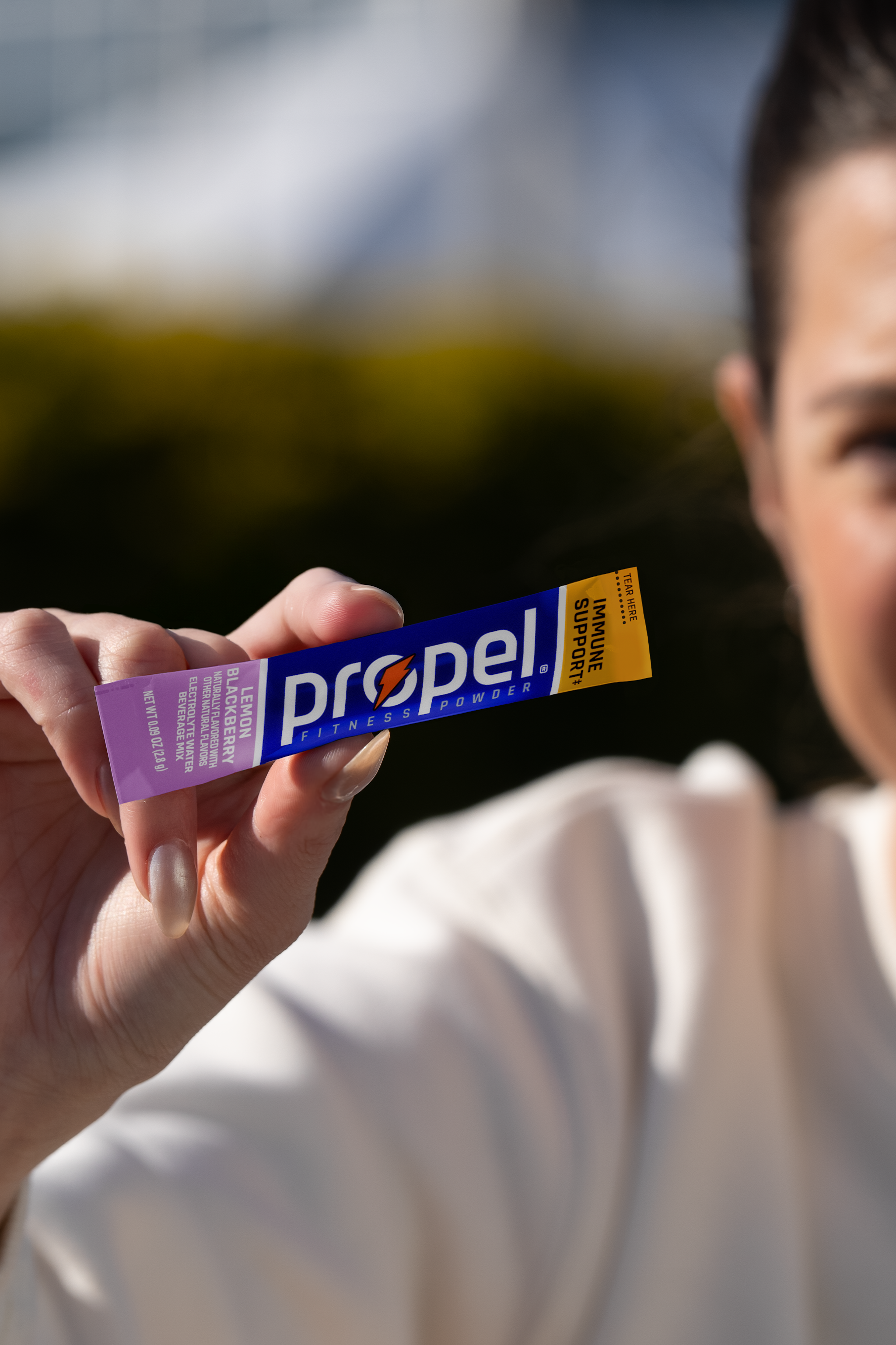 Propel powder lemon blackberry in athletes hand
