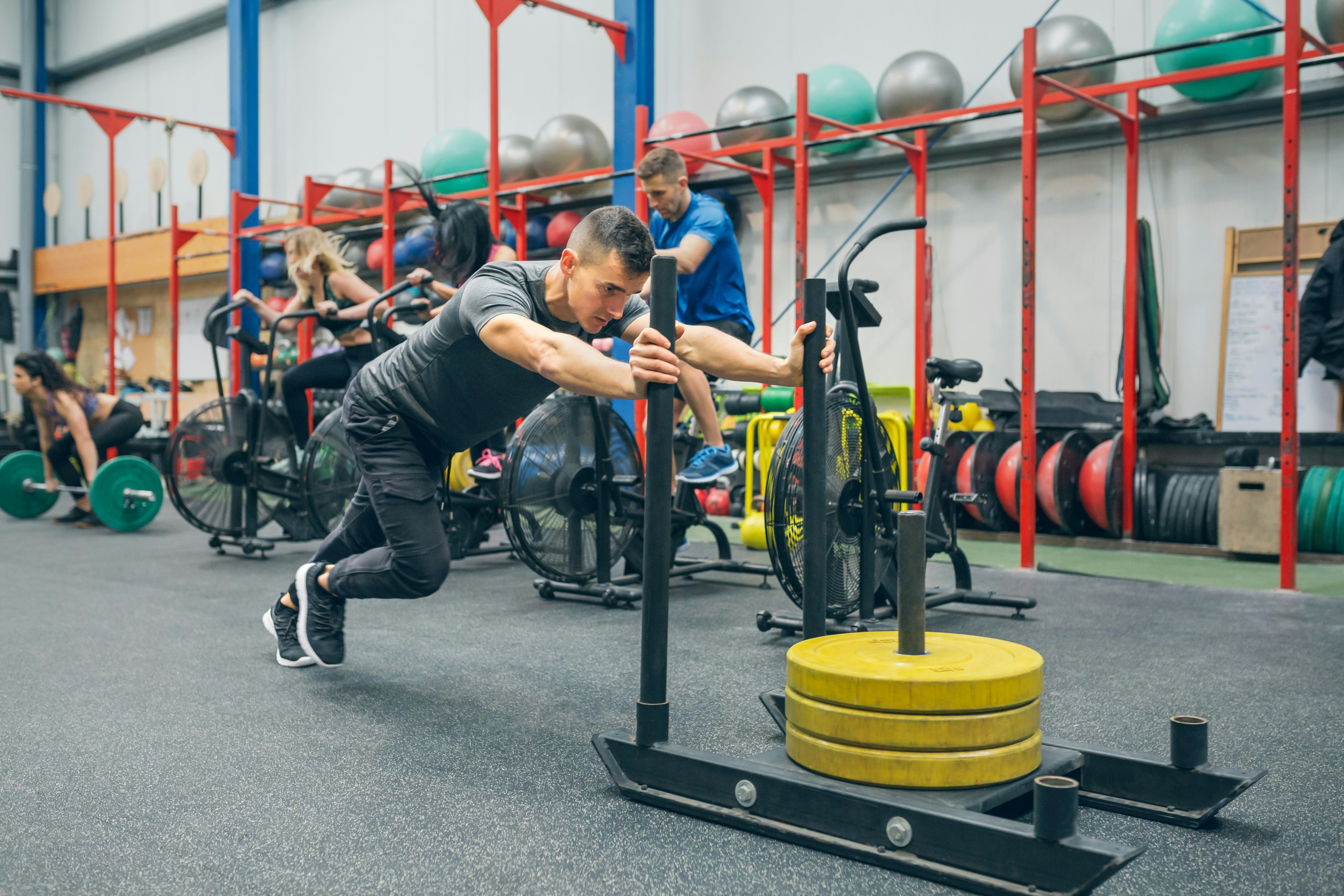 man pushing weight sled