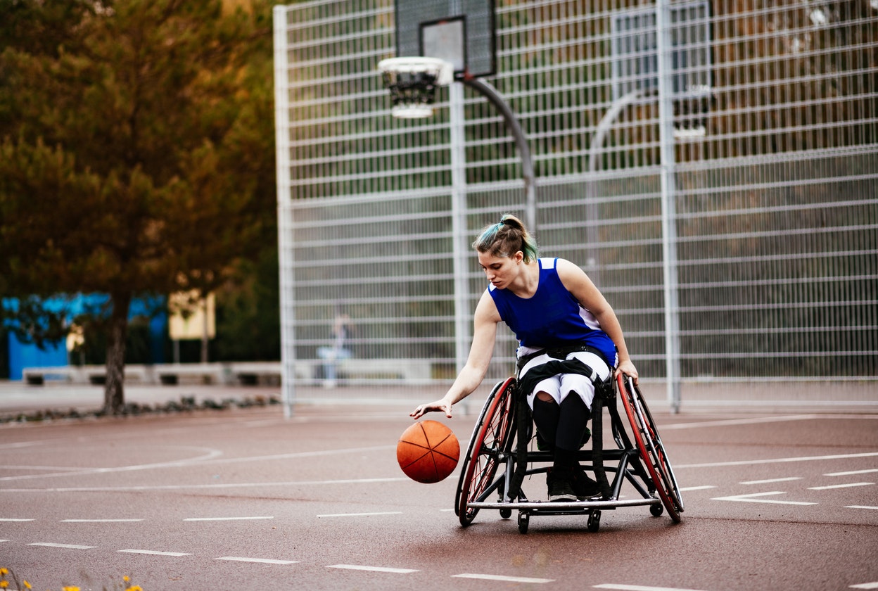 woman in wheelchair playing basketball