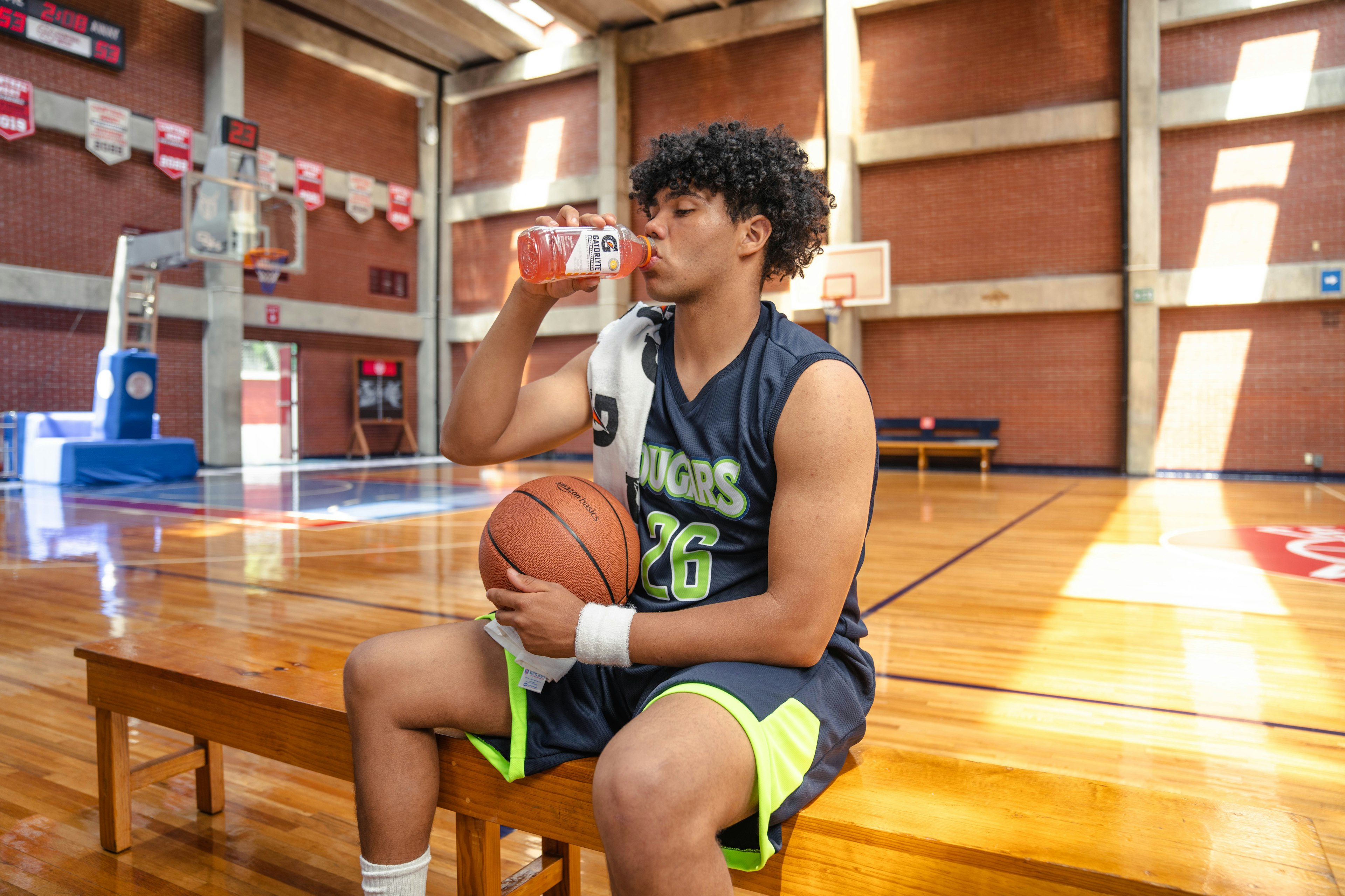 man drinking gatorlyte holding basketball