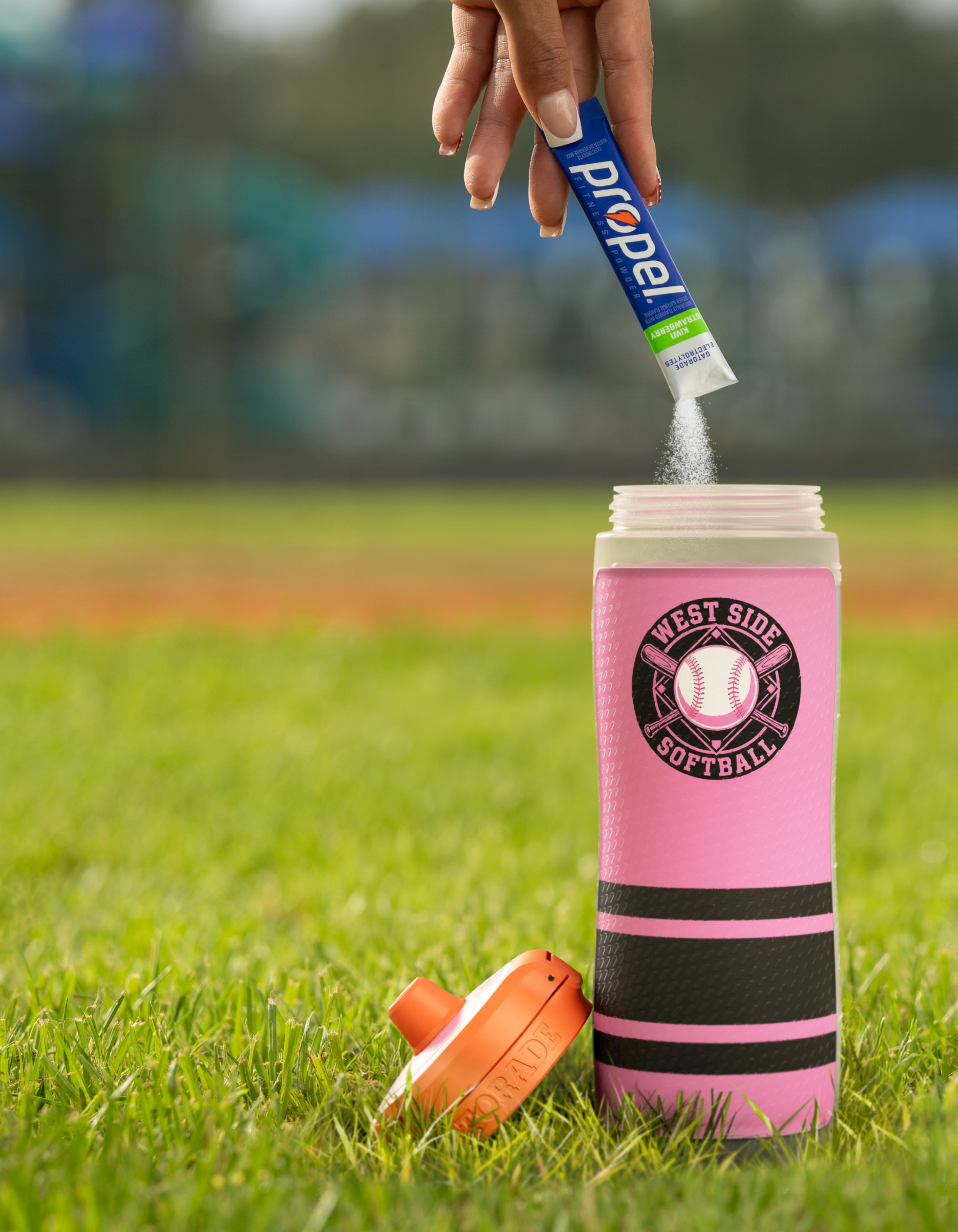 Propel powder being poured into Gatorade custom squeeze bottle