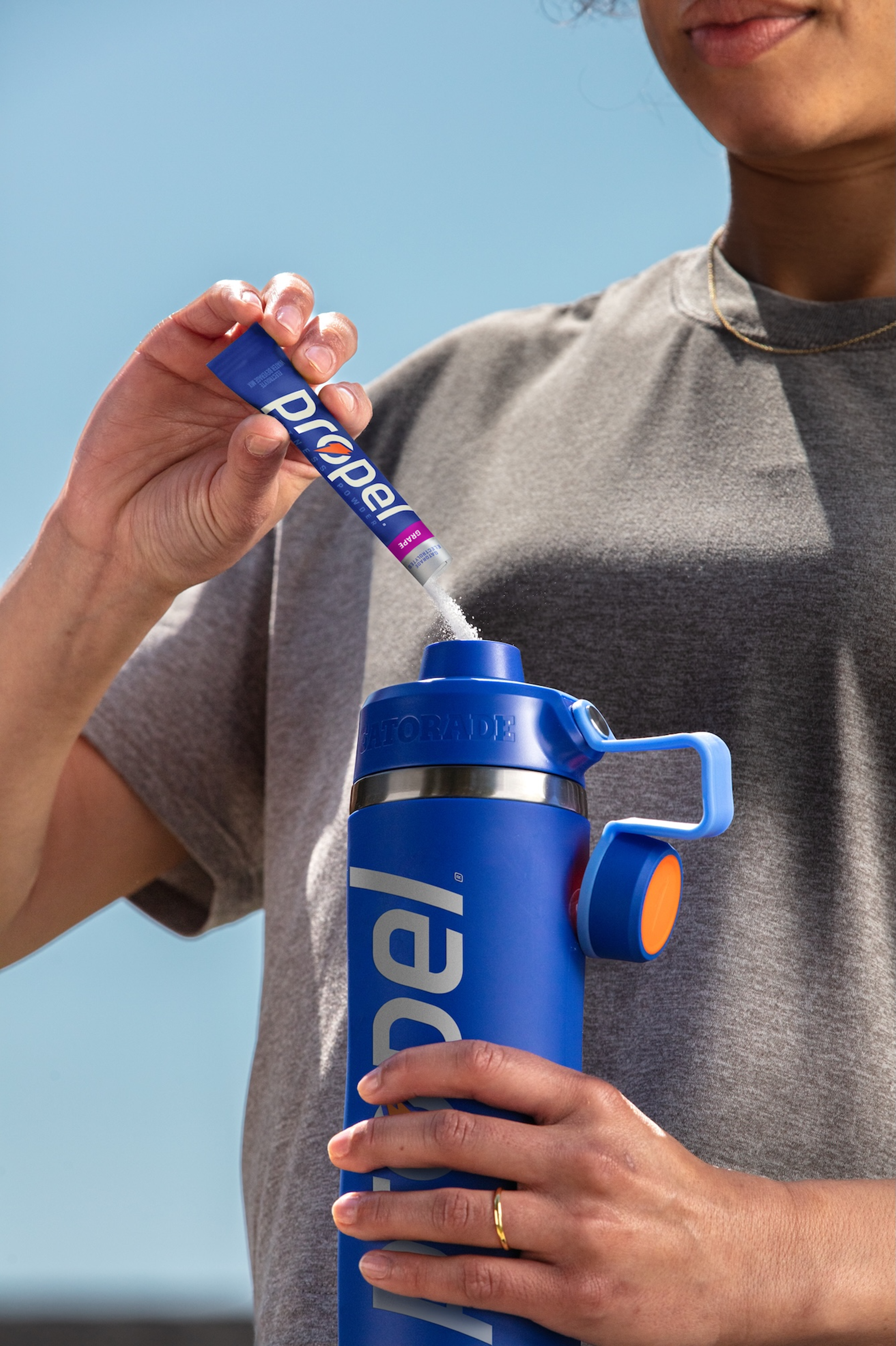 propel single serve powder grape being poured into overtime bottle