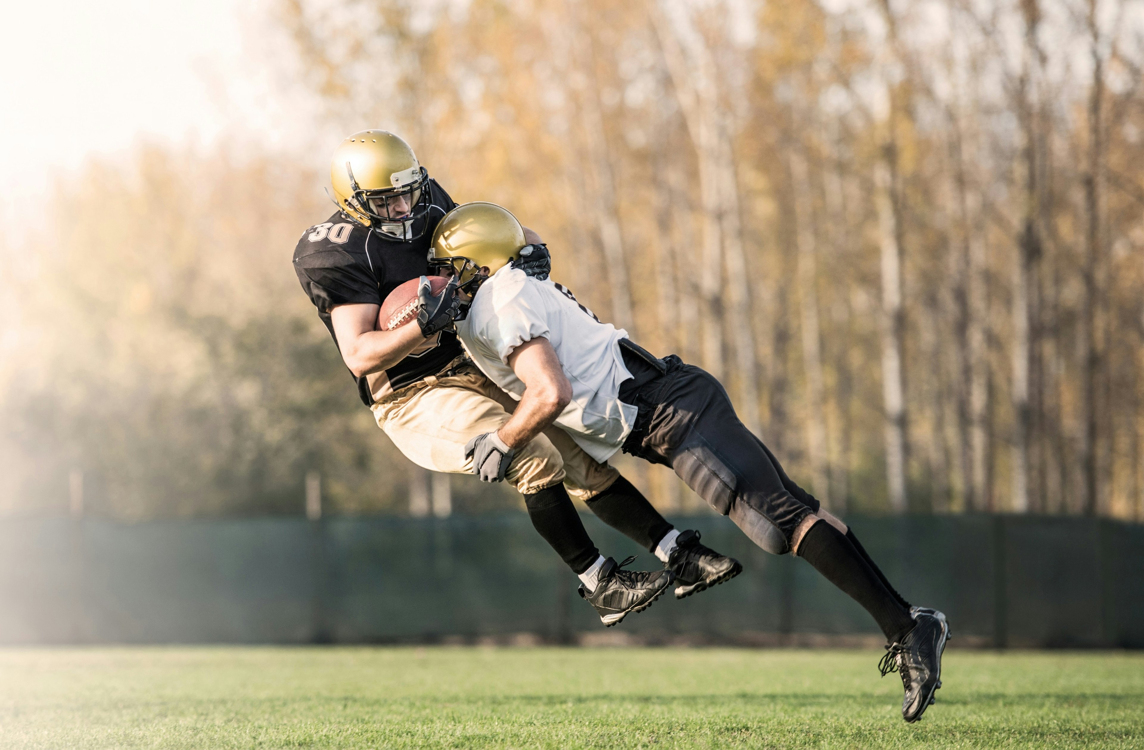 football player tackling another
