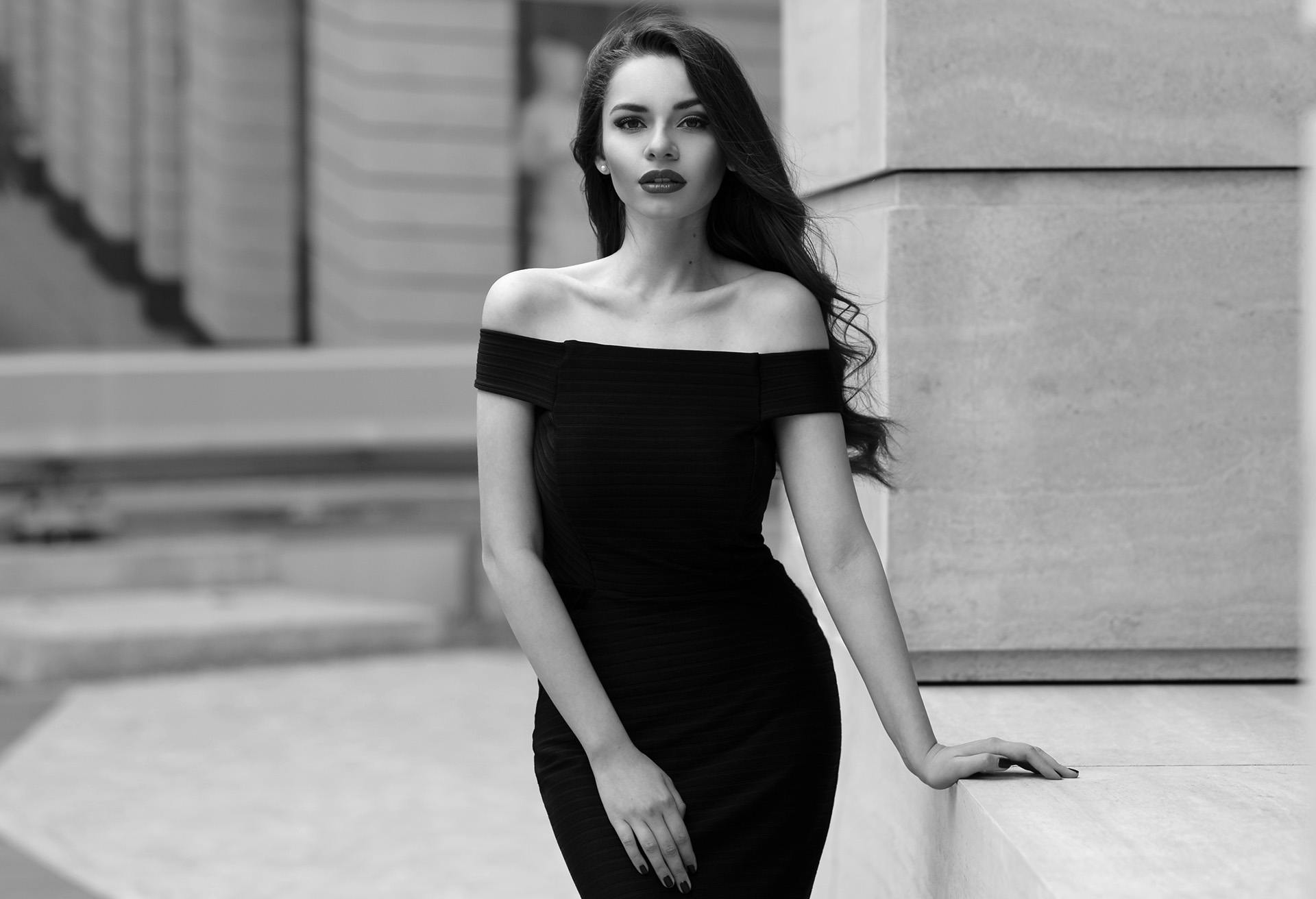 Black and white image of a woman in a sexy black dress
