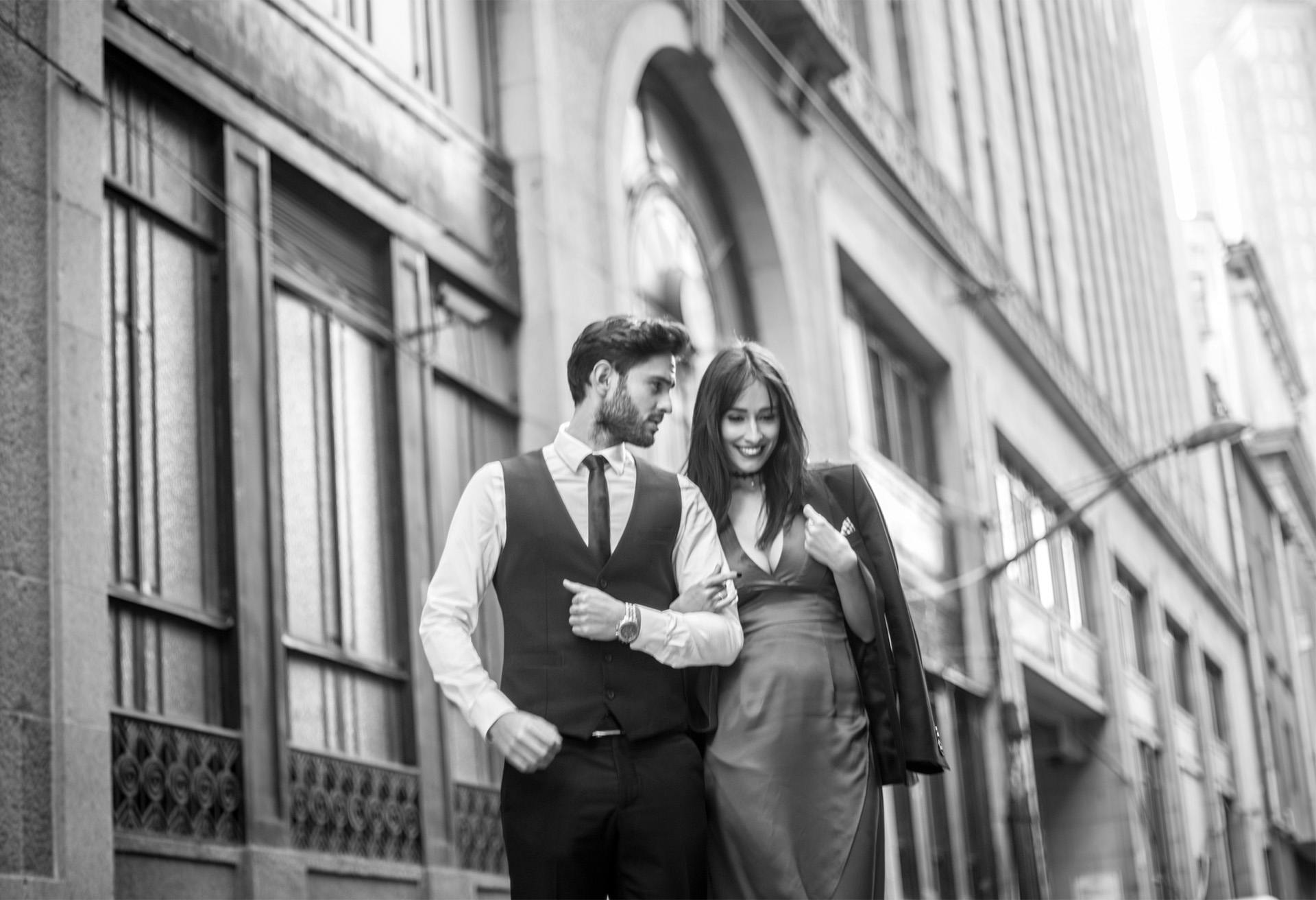 Black and white image of a couple dressed up walking downtown