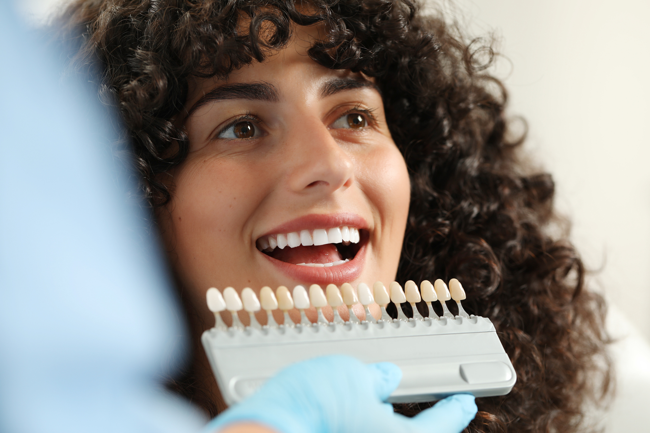 Patient comparing tooth shade samples during cosmetic dentistry consultation
