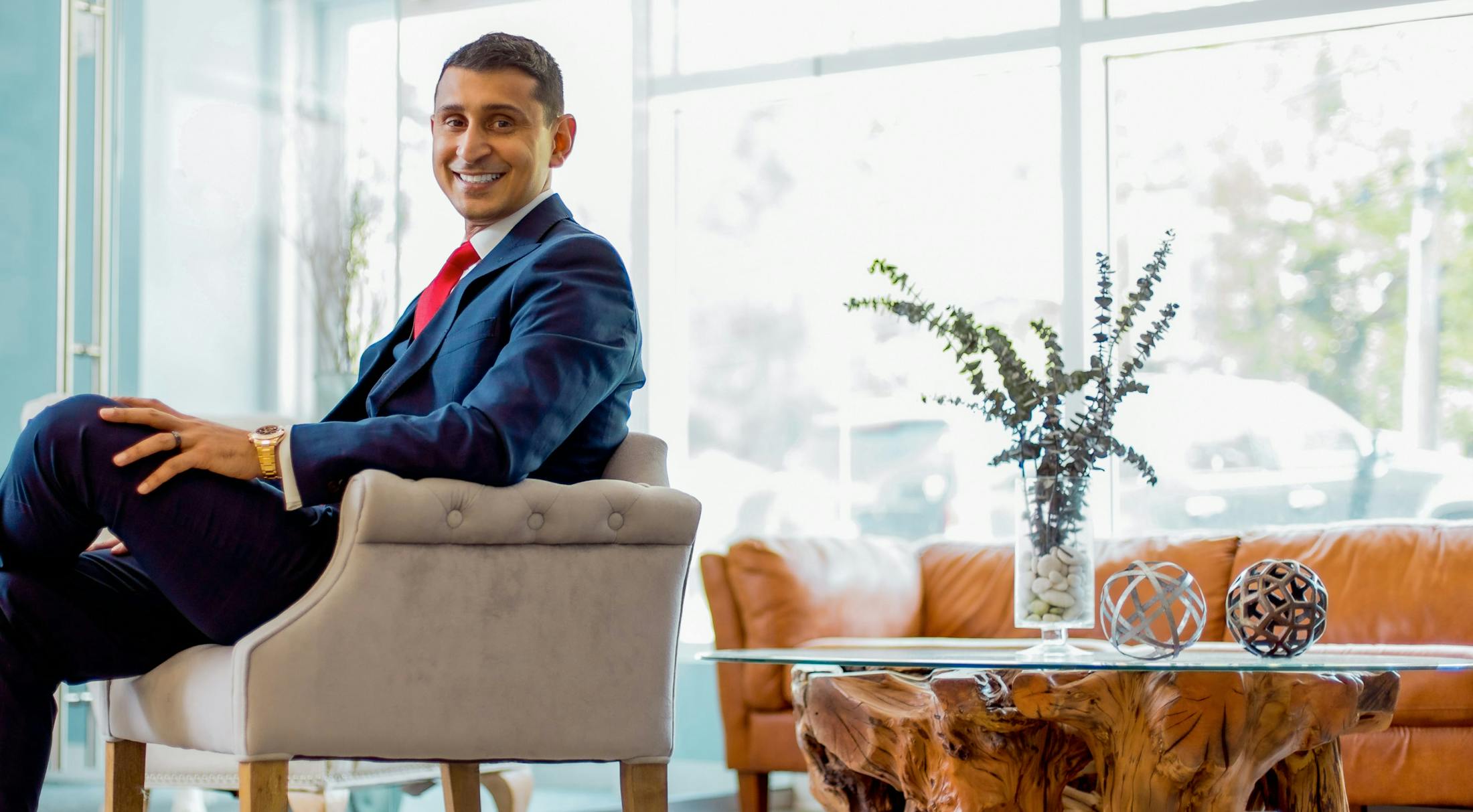 Dr. Omar Shakir smiling and sitting