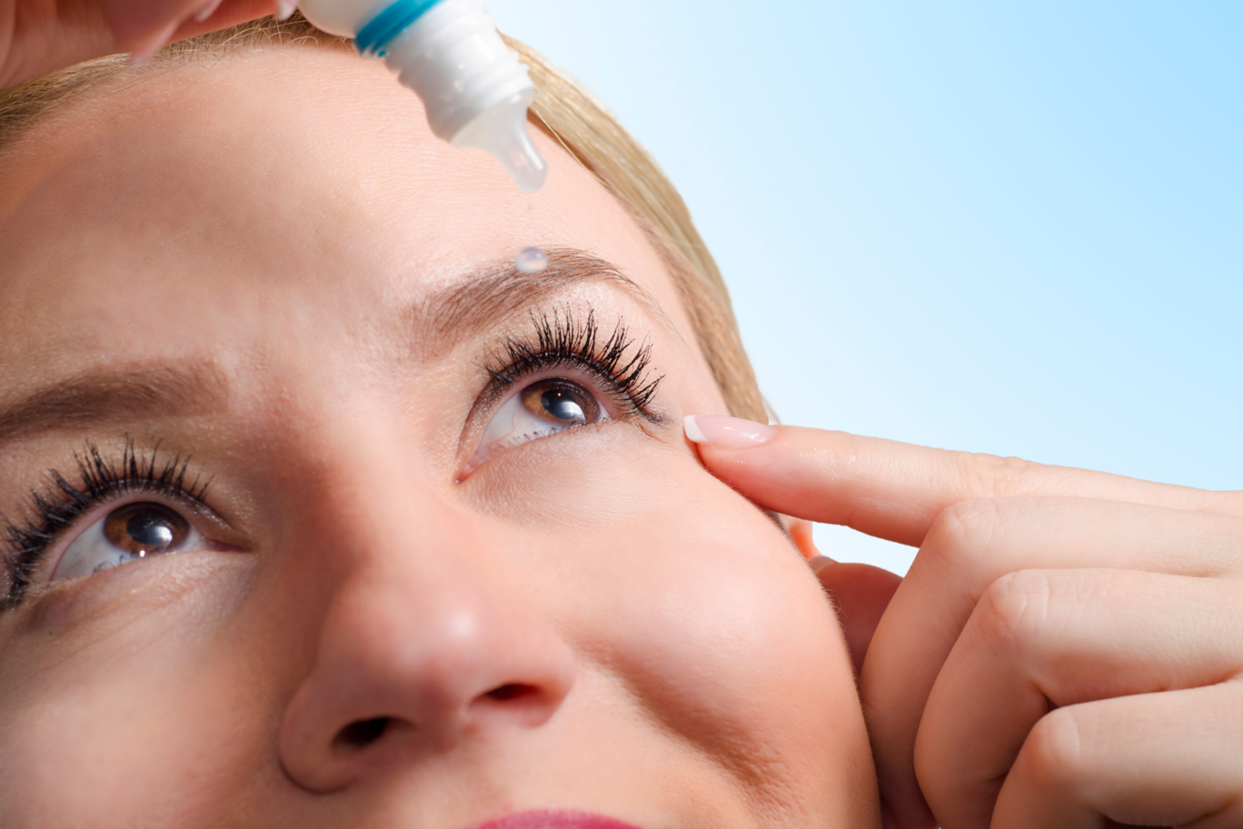 Woman using eye drops