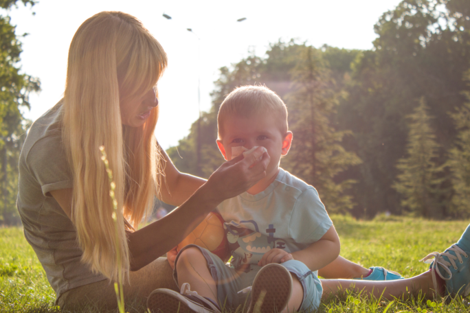 mother helping child blow their nose