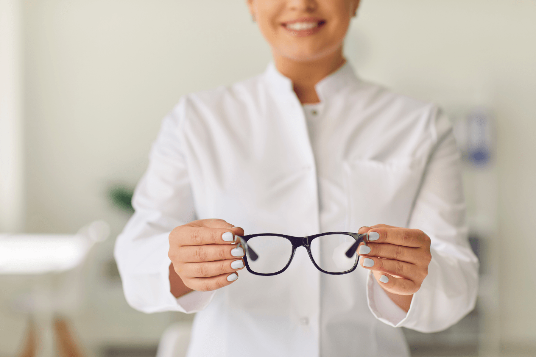 woman smiling and holding glasses