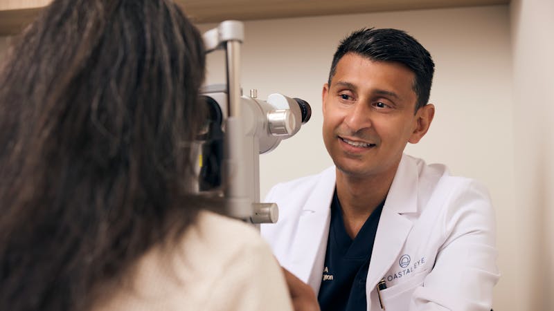 Dr. Shakir speaking with a patient during an eye exam at Coastal Eye.