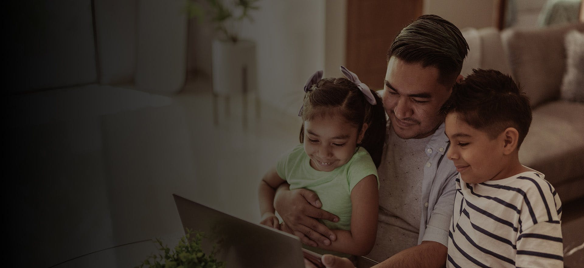 there is a man and two children looking at a laptop