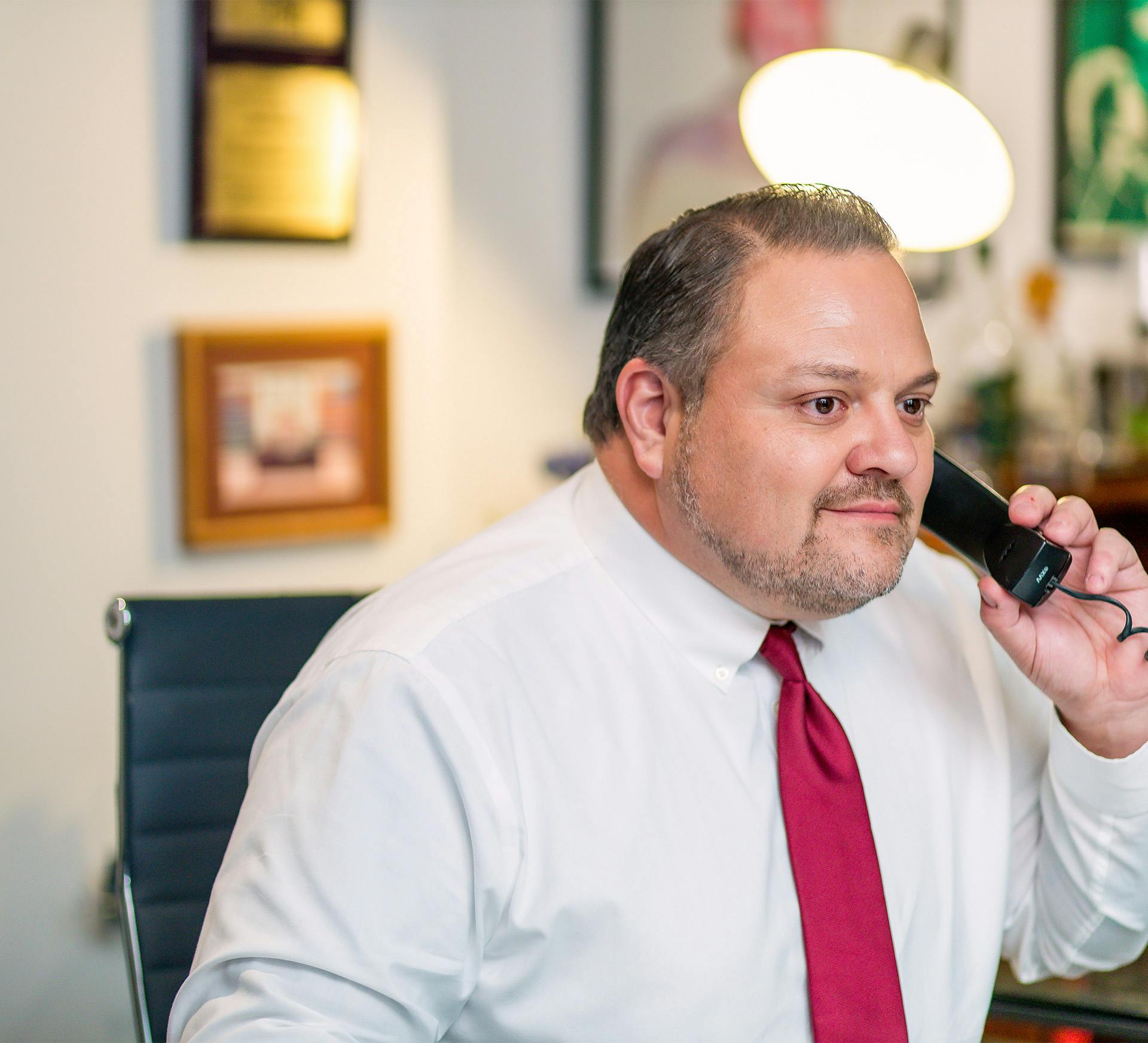 Mauro Fione Jr. with Fiore Legal Injury Attorneys on a cell phone sitting in his office