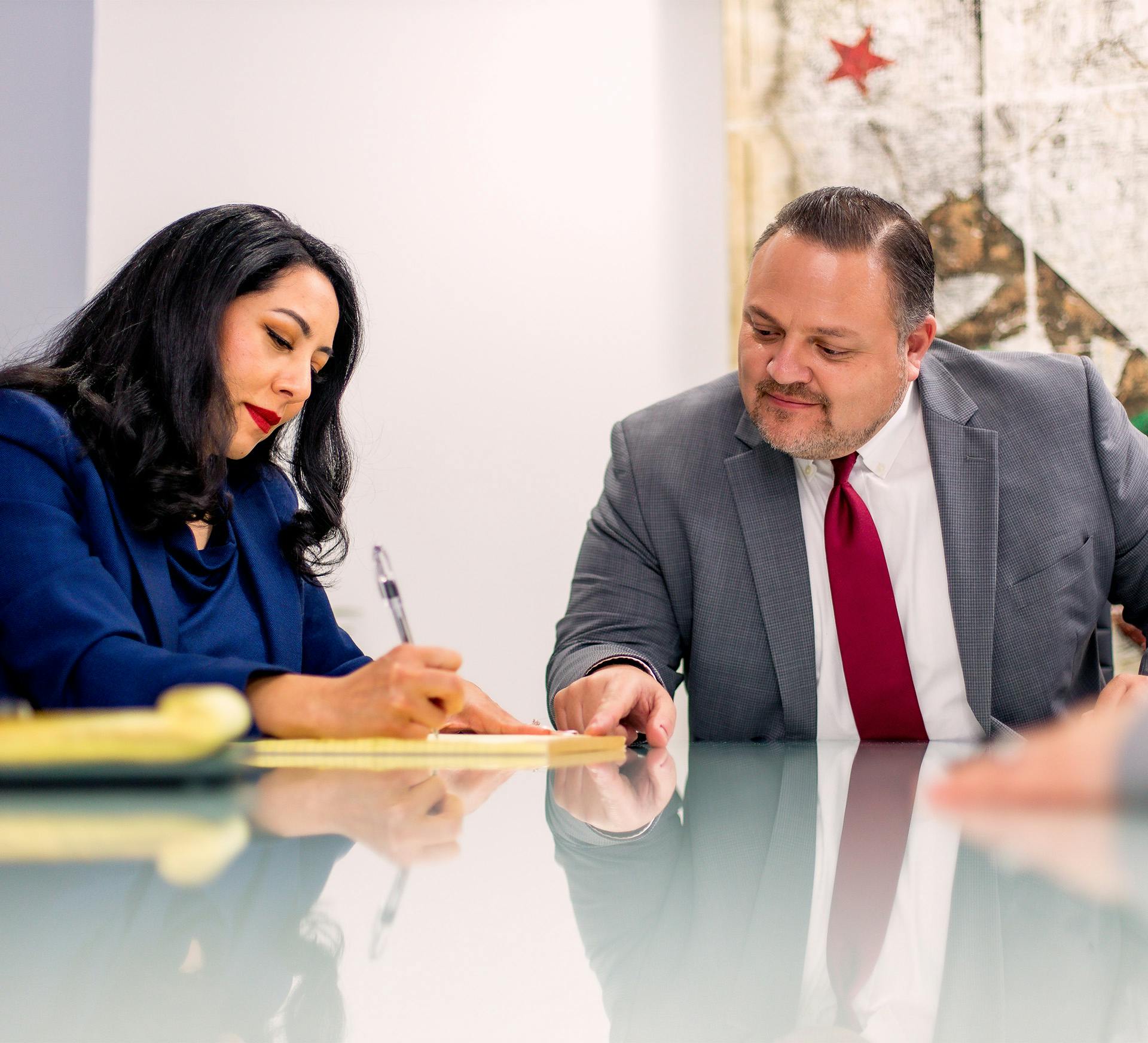 Mauro Fiore Jr. and Krystale Rosal with Fiore Legal Injury Attorneys signing paperwork together