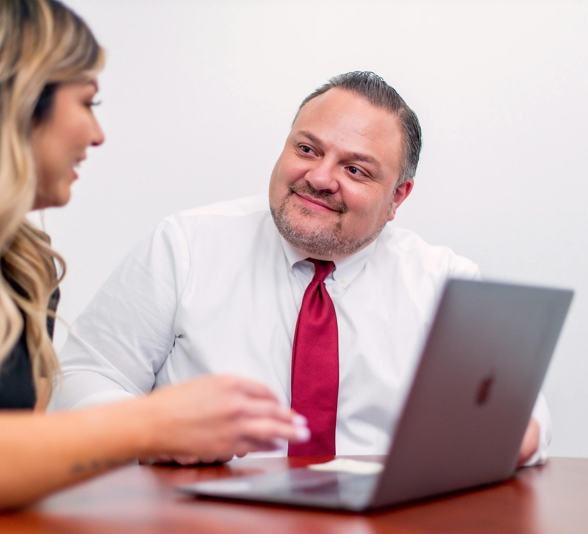 Mauro Fiore Jr. with Fiore Legal Injury Attorneys working with a client at a laptop