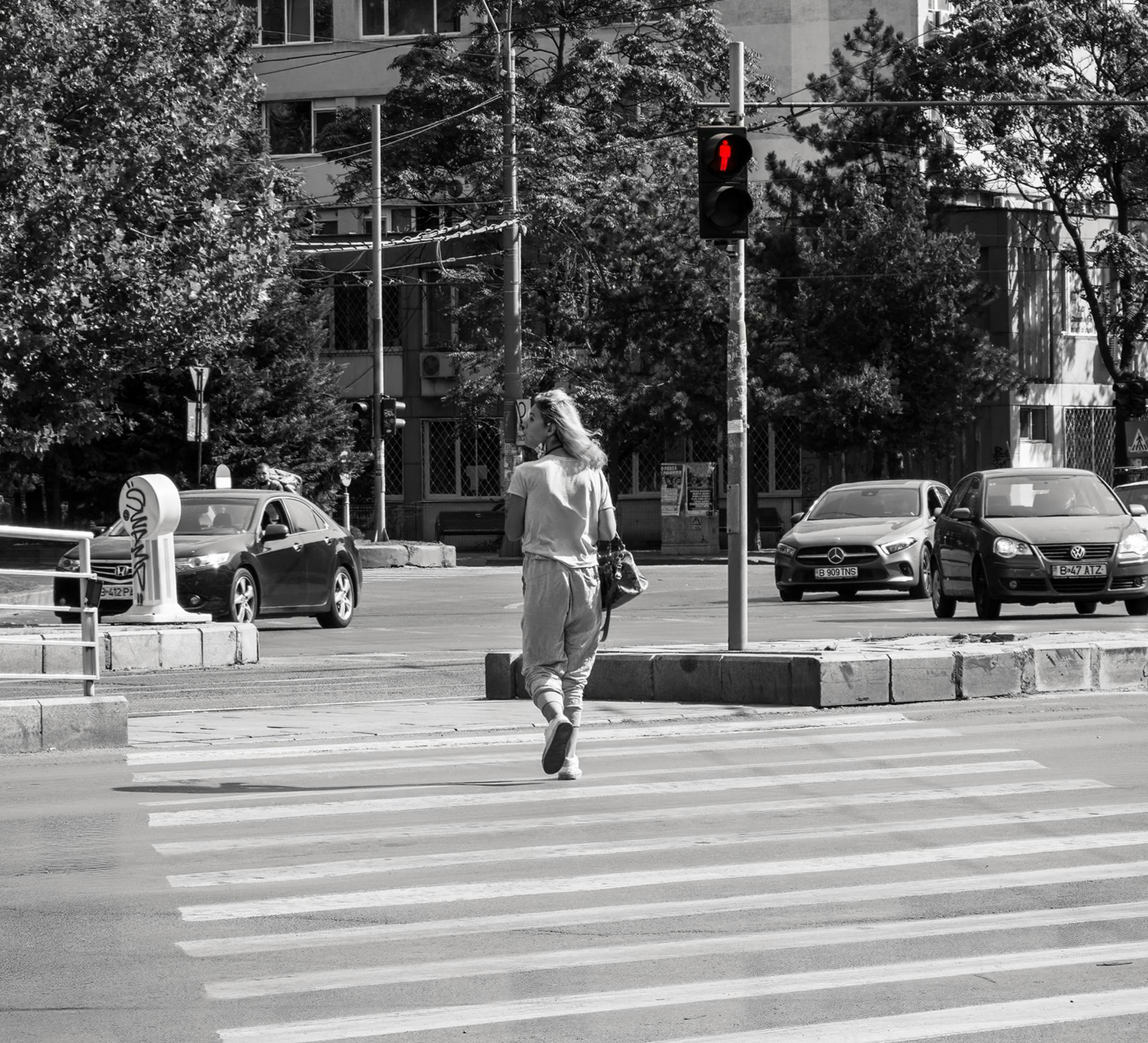 a woman crossing the street at a crosswalk