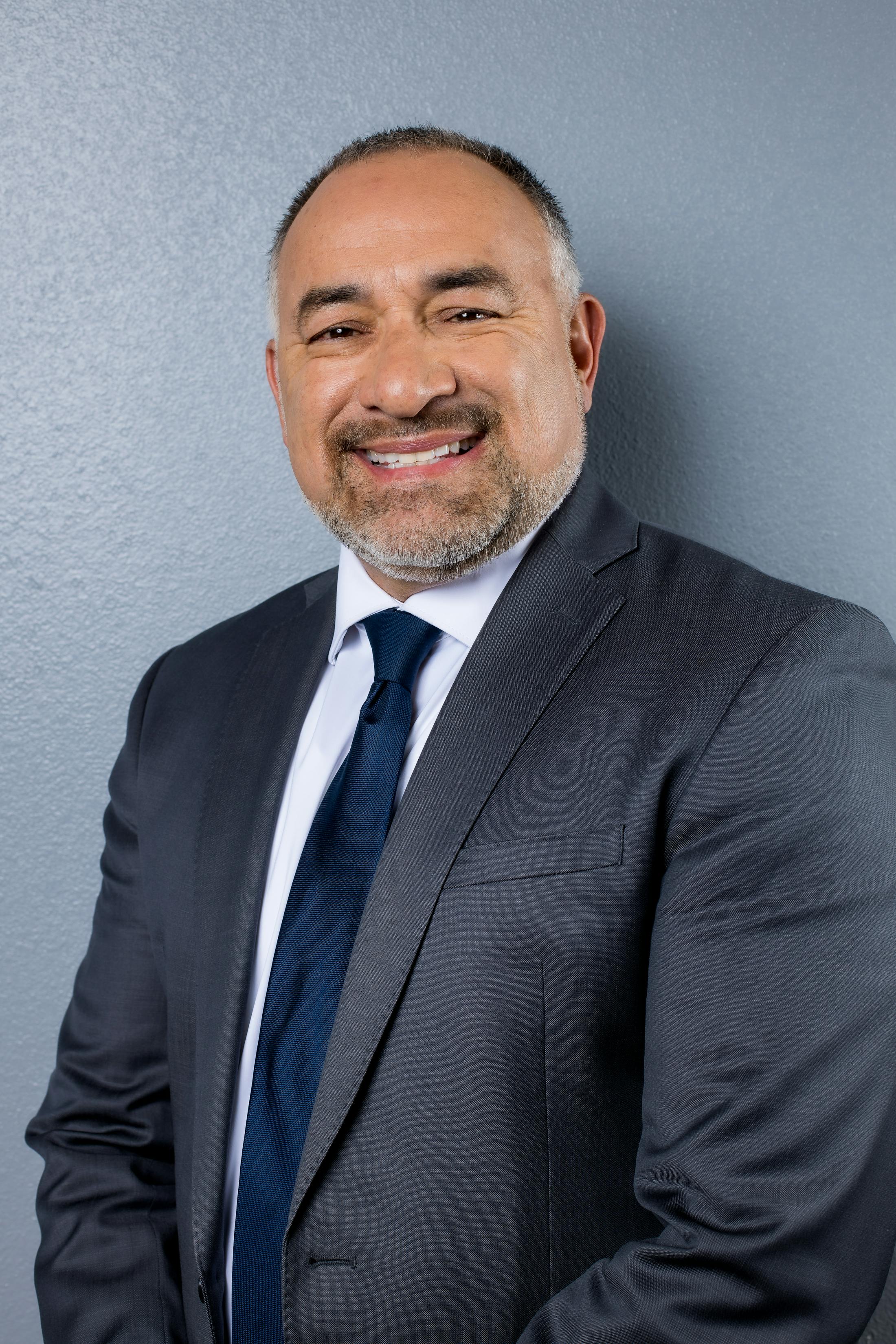 Gilbert Perez III with Fiore Legal Injury Attorneys in grey suit and blue tie