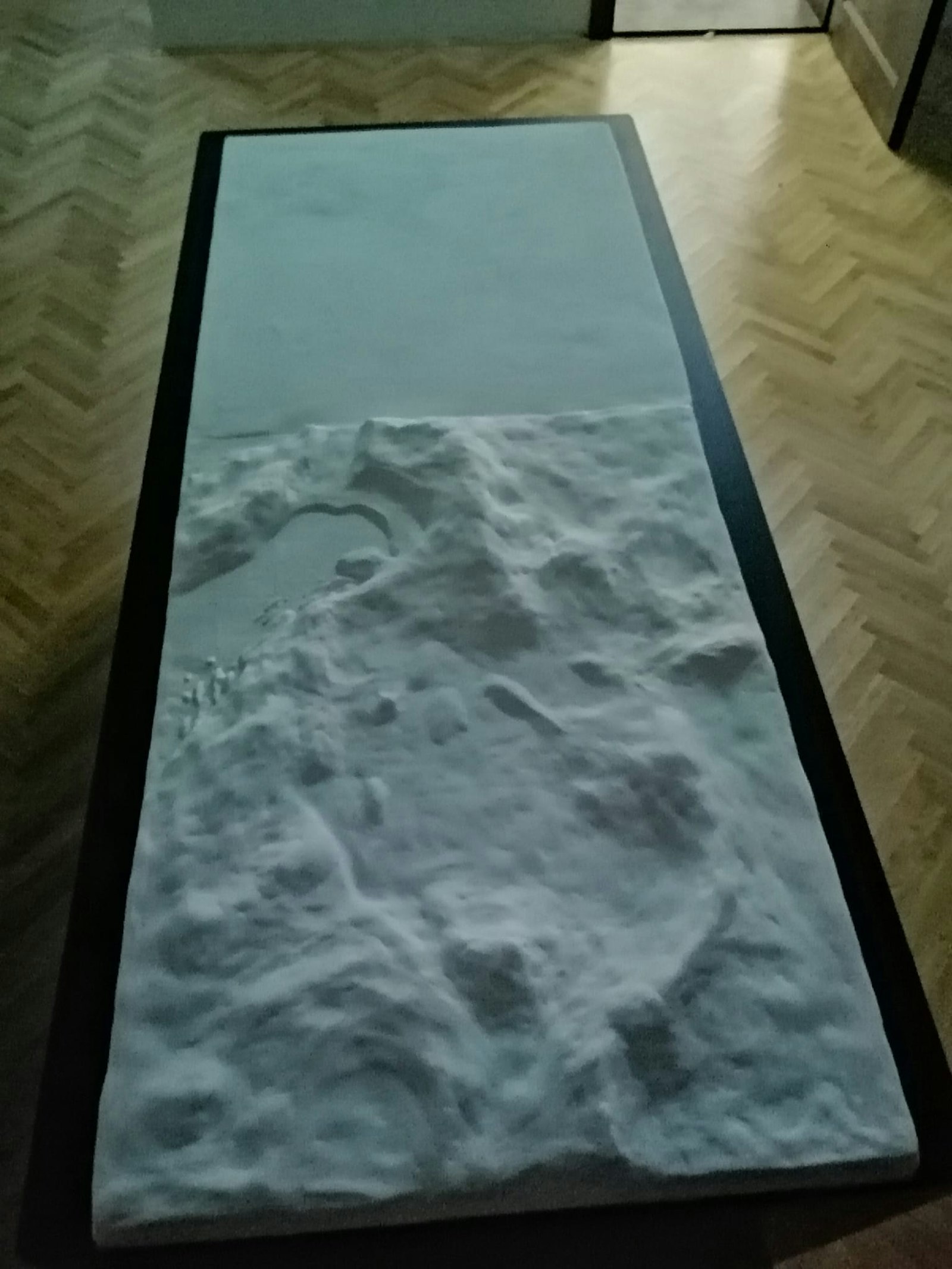 Photo of the blank white physical relief model on its stand before the projection is applied.