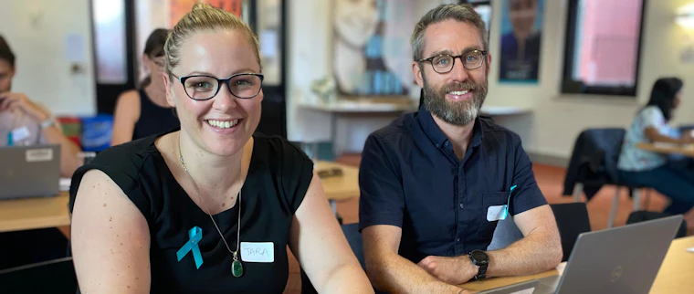 Woman and man sitting at a desk smiling