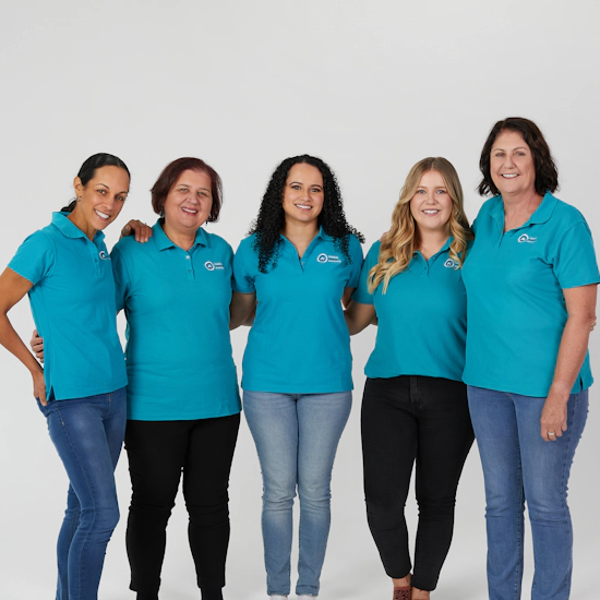 Five women wearing teal polo shirts