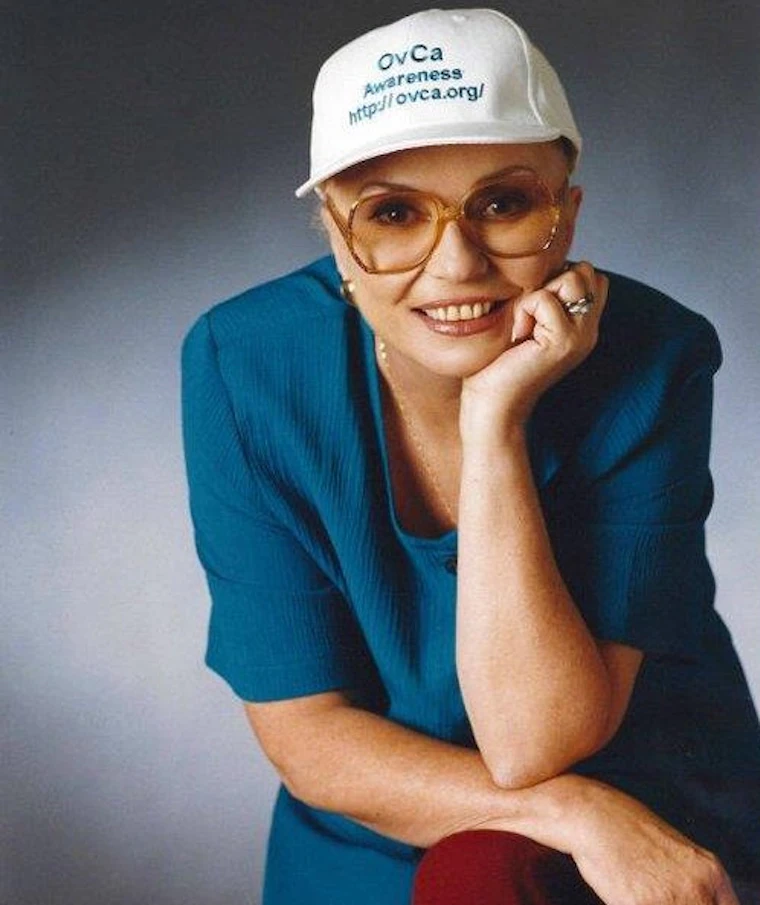 Woman wearing a white baseball cap and glasses