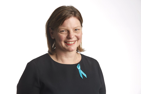 Woman wearing a black top and teal ribbon