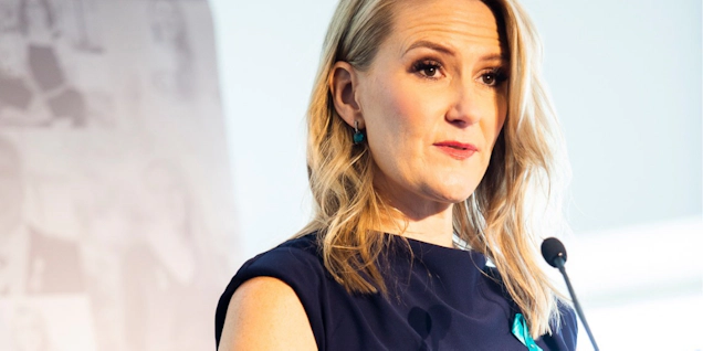 Woman in blue dress standing at microphone