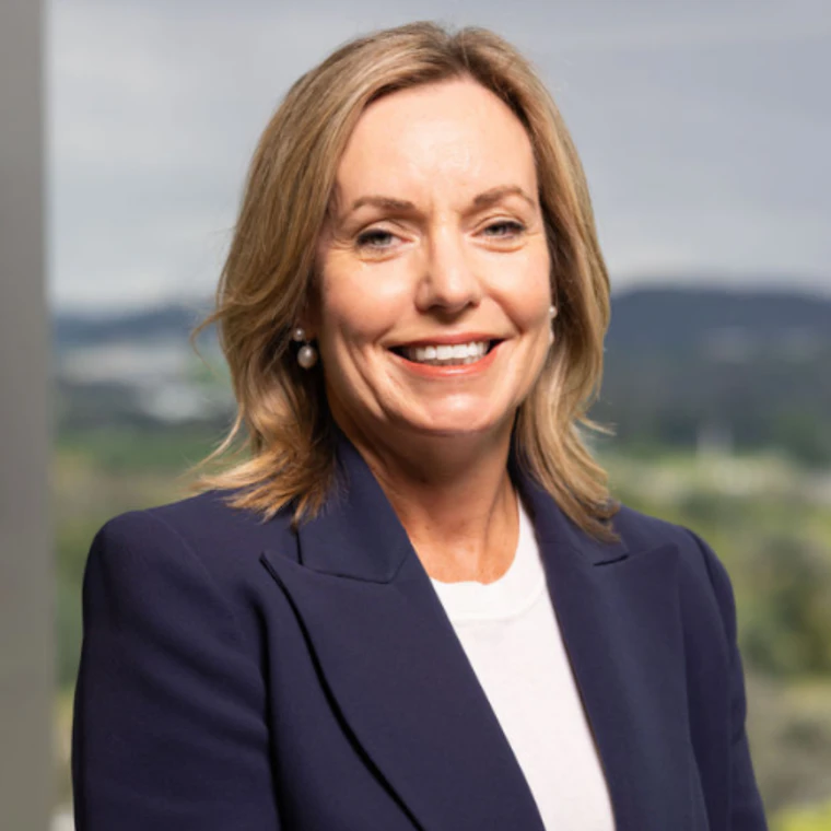 Woman with blonde hair in a navy suit