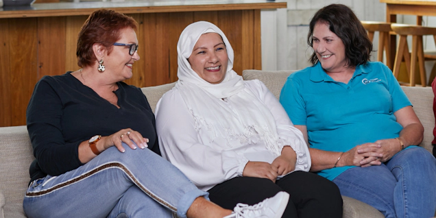Teal support nurse with two women with ovarian cancer sitting on couch talking