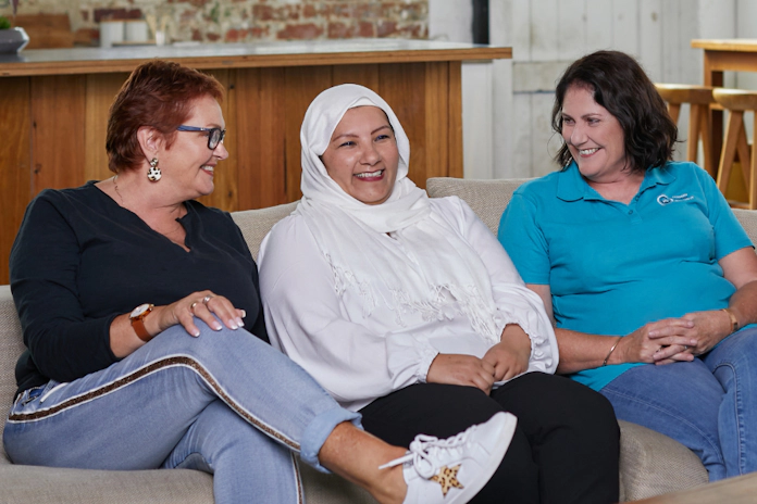 Teal support nurse with two women with ovarian cancer sitting on couch talking