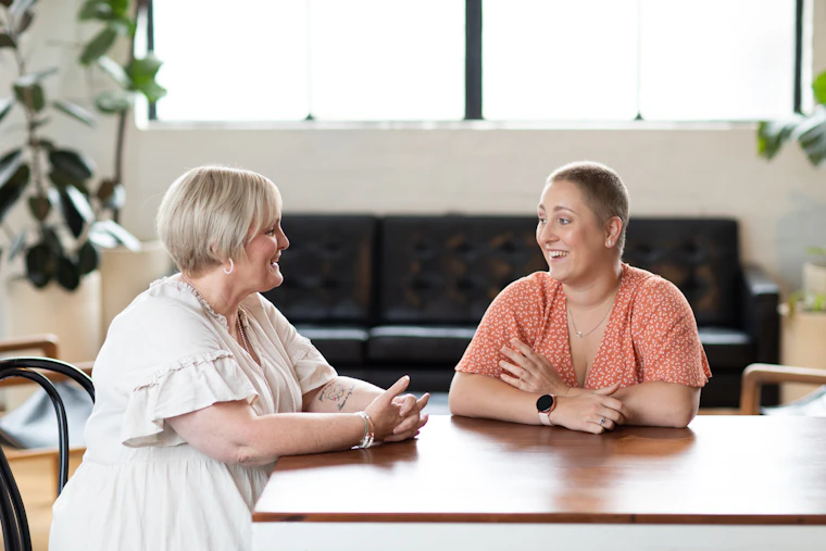 two women with ovarian cancer sitting at a table talking