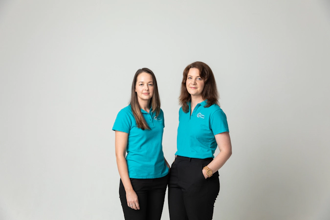 two support team members from ovarian cancer australia in teal shirts