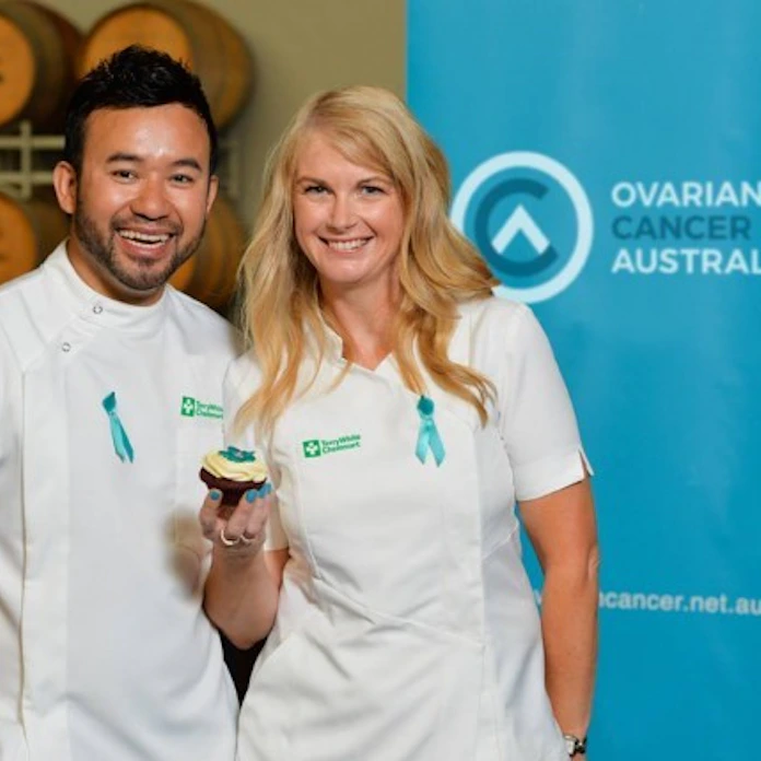 two chemists from Terrywhite Chemmart wearing teal ribbons in support for ovarian cancer australia.