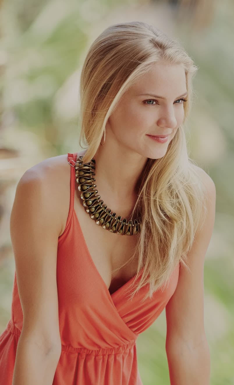 Smiling woman with a background of foliage.