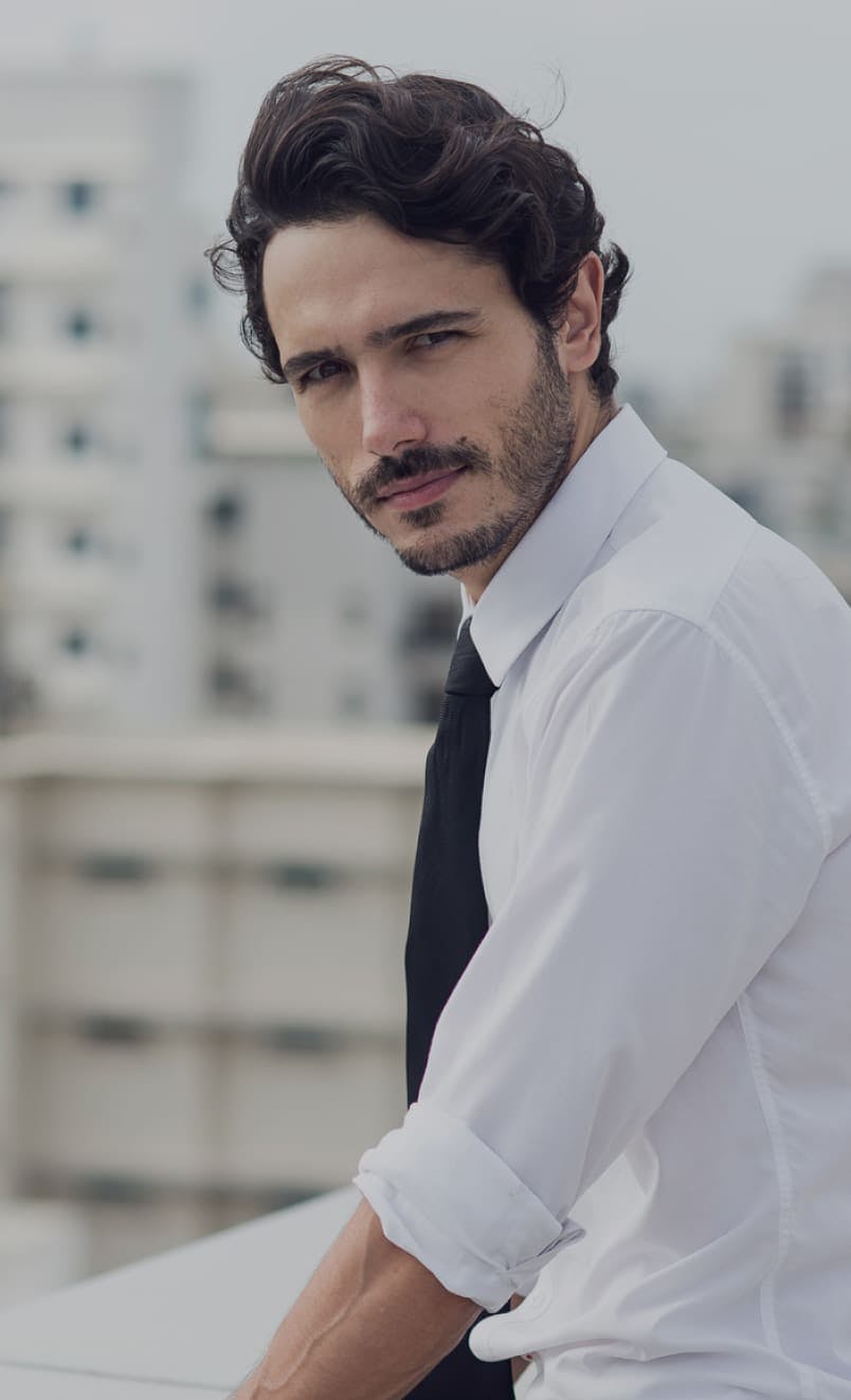 Man sitting on a windy rooftop.