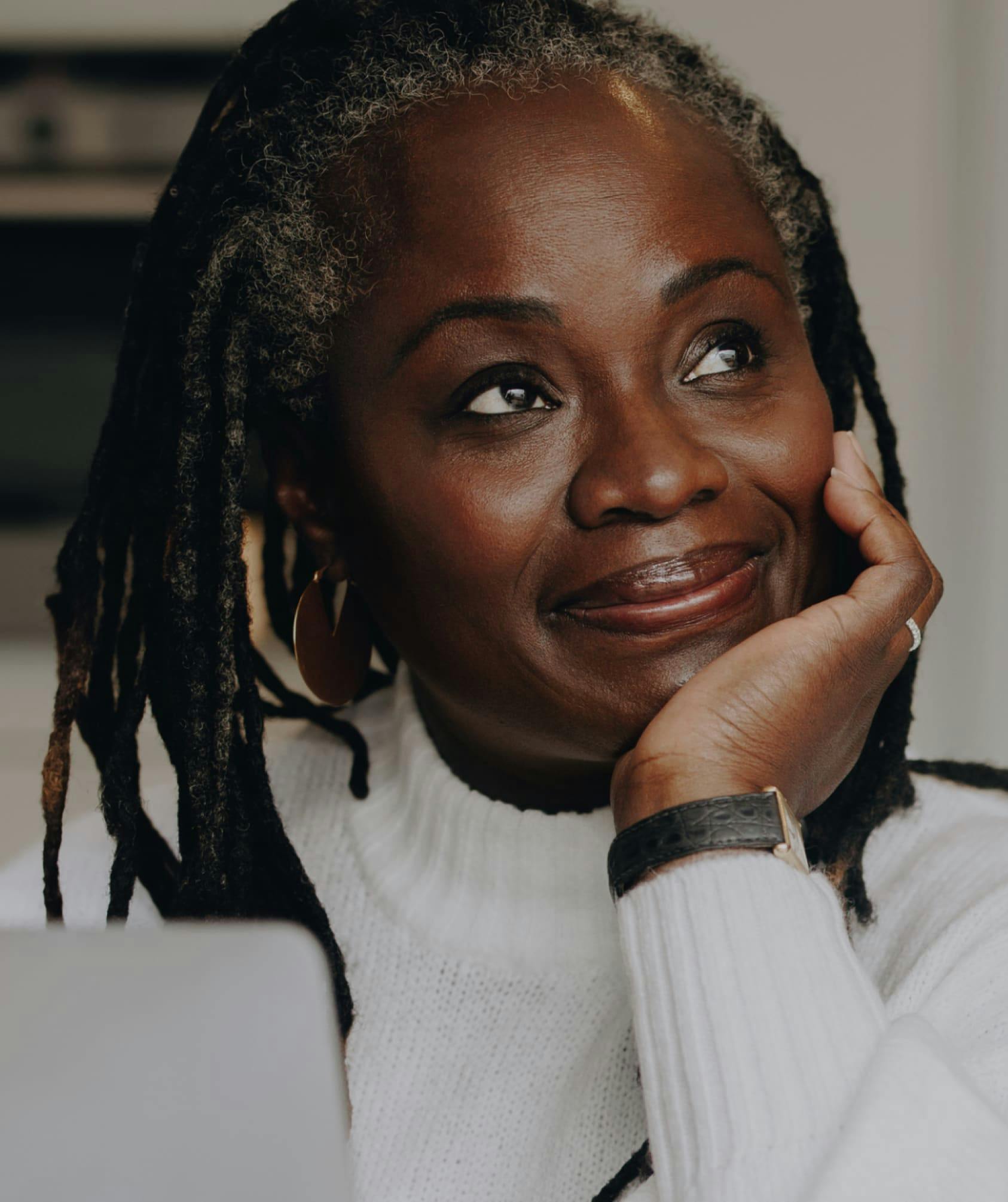Smiling woman with her chin on her hand.