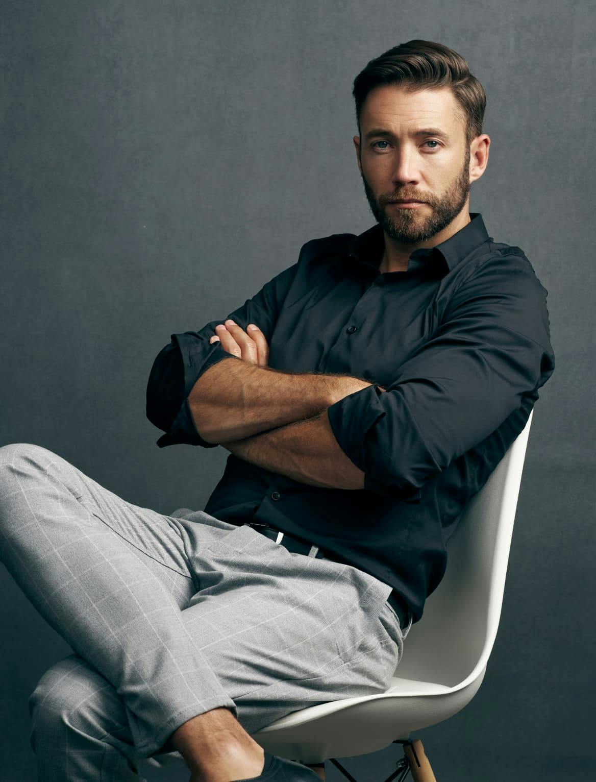 A well-dressed man sitting in a chair.