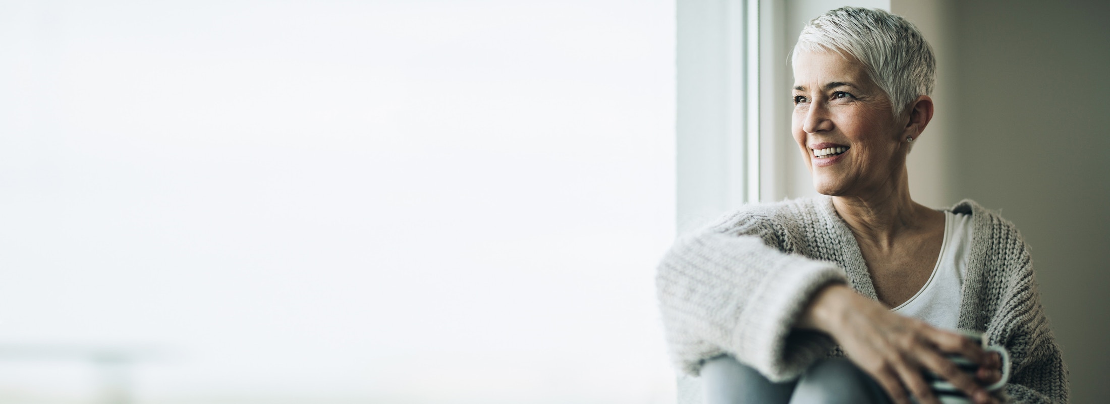 older woman with short hair looking out window