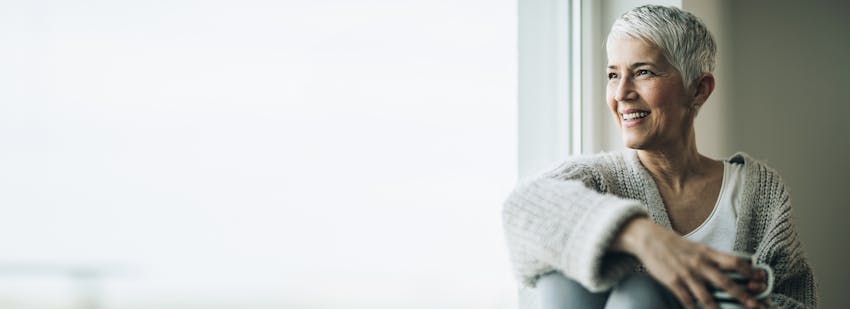 older woman with short hair looking out window